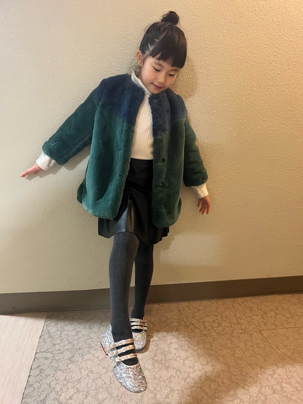 「クリスマスに着たい服、キッズファッション、女の子コーデ、モード、ファーコート、ミニスカート、おんなのこ、小学生、おだんごヘアー、もこもこ、冬コーデ、レザー、スカート、バレエシューズ」｜「venitのアイテム（ムートンコート、グリーン系）」を使った、pecocoさん（キッズ・120cm）の冬コーディネートの1枚目の写真