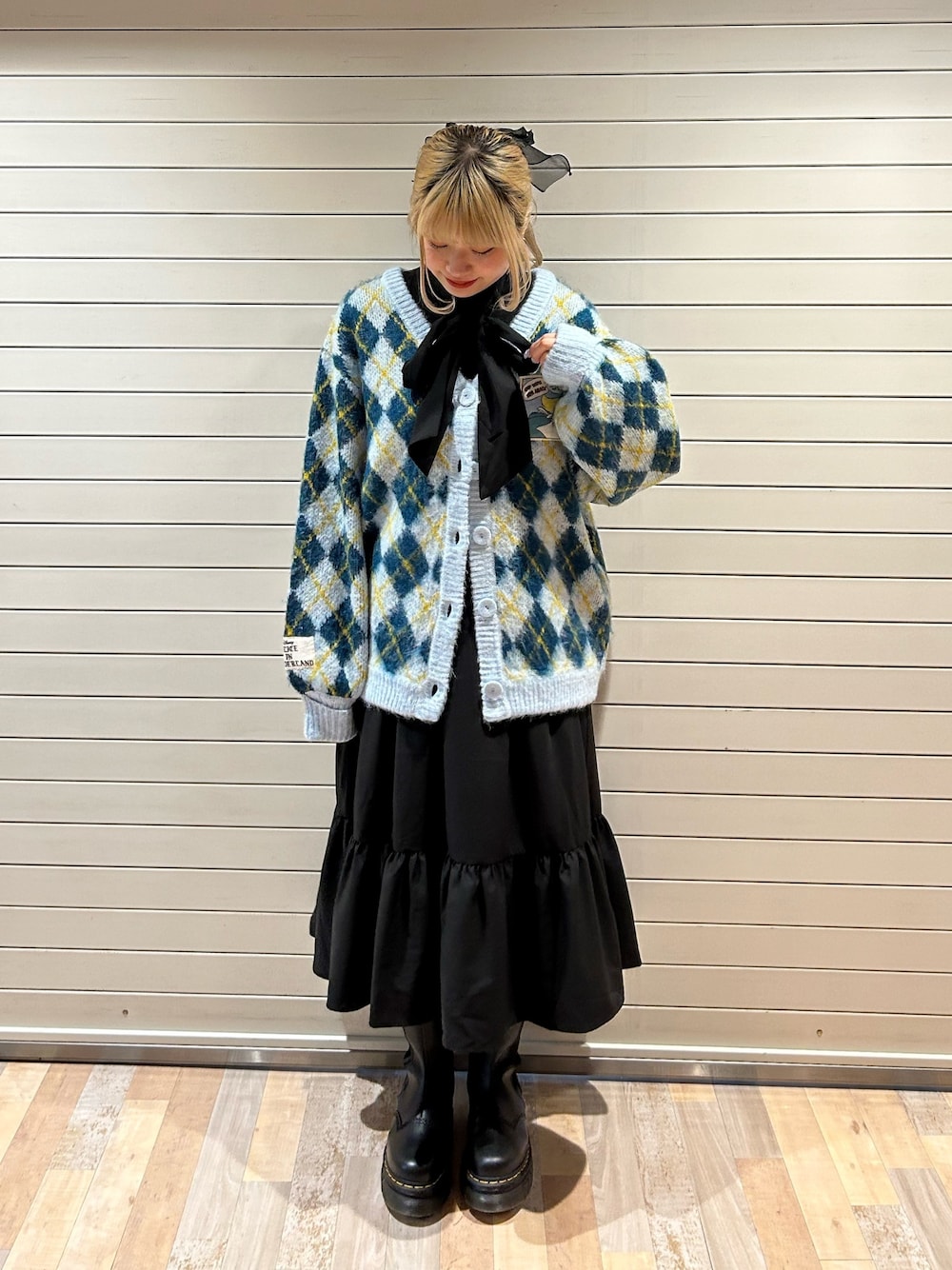 ブラック系のブーツ、ブルー系のカーディガン/ボレロ、ブラック系のワンピースを着用したレディースの秋コーディネートの1枚目の写真