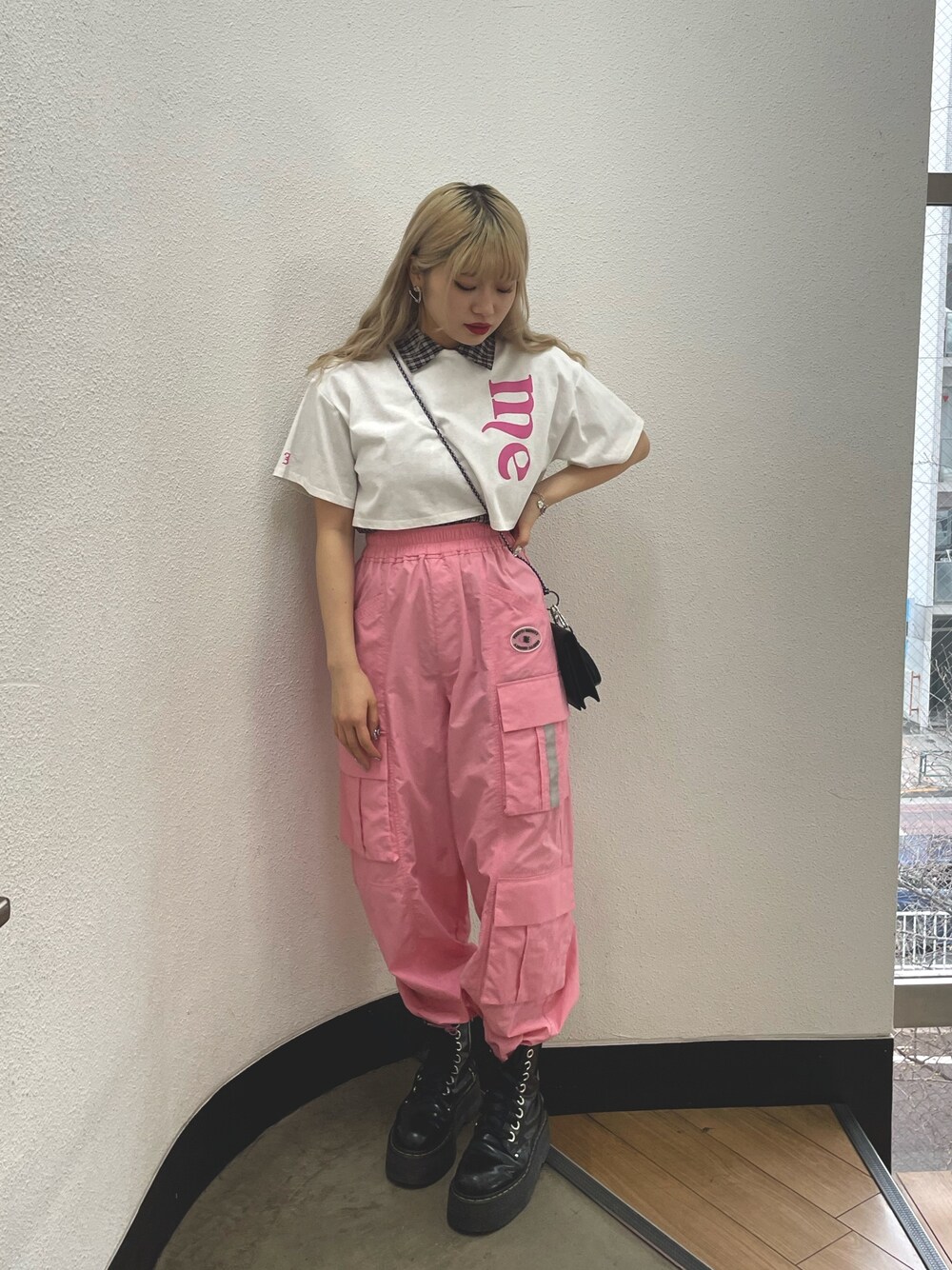 ピンク系のカーゴパンツ、ブラック系のその他シューズ、ホワイト系のTシャツ/カットソーを着用したレディースの春コーディネートの1枚目の写真