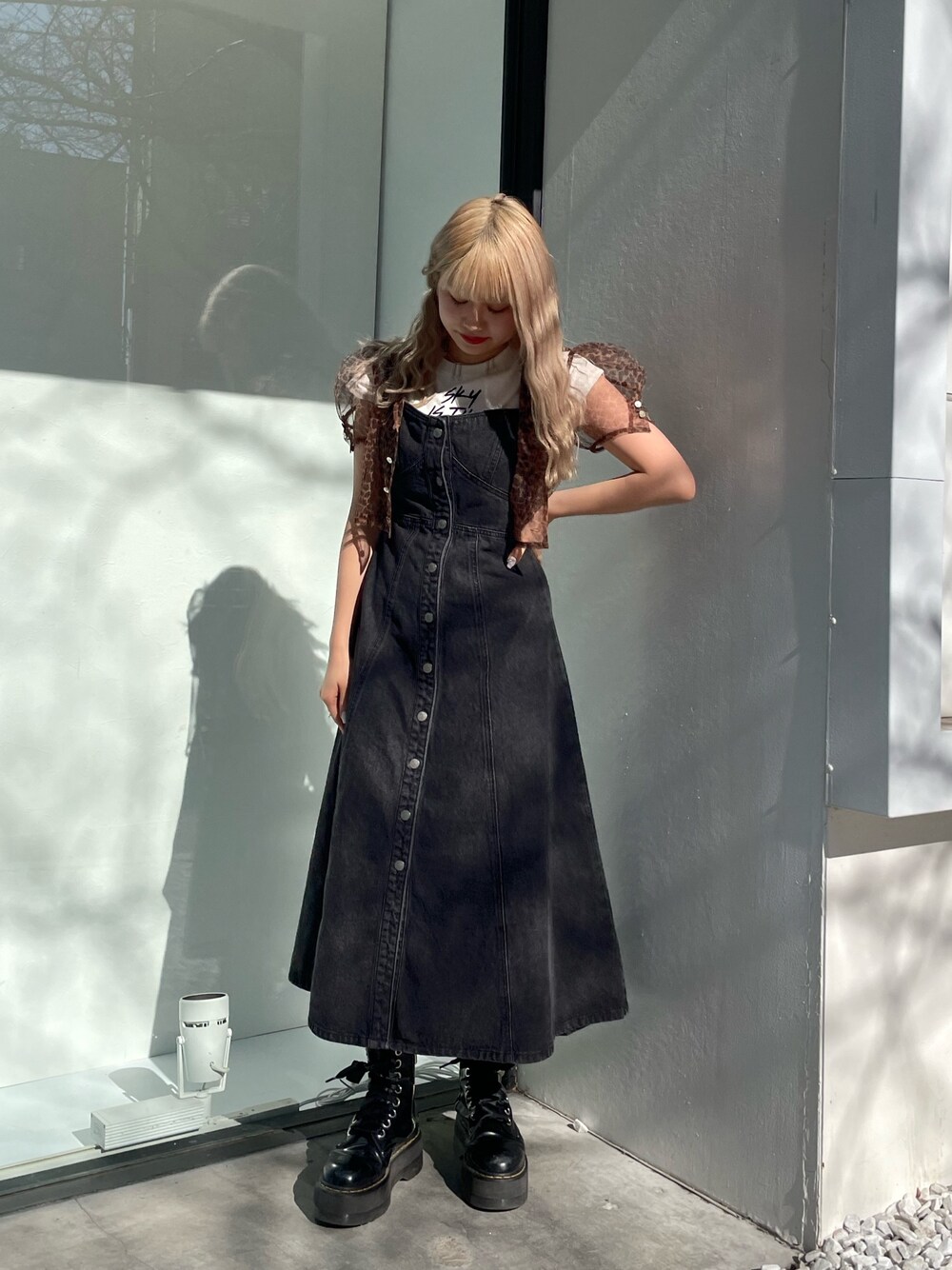 ブラック系のジャンパースカート、ホワイト系のタンクトップ、ブラウン系のシャツ/ブラウスを着用したレディースの春コーディネートの1枚目の写真