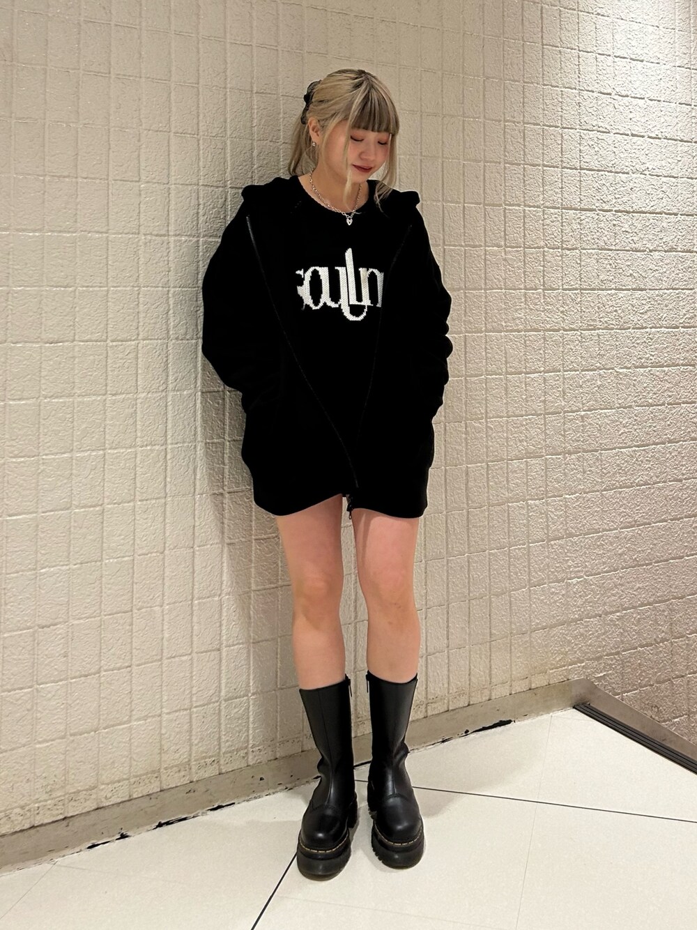 ブラック系のニット/セーター、ブラック系のブーツ、ブラック系のパーカーを着用したレディースの冬コーディネートの1枚目の写真