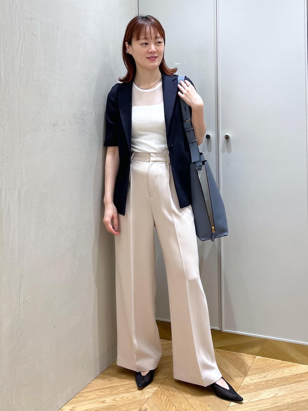 ブルー系のショルダーバッグ、ブラック系のパンプス、ベージュ系のその他パンツを着用したレディースの夏コーディネートの1枚目の写真