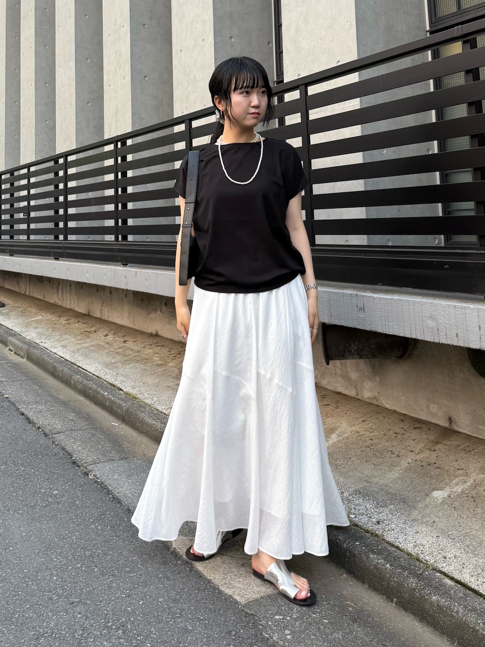 ブラック系のTシャツ/カットソー、ホワイト系のスカートを着用したレディースの夏コーディネートの1枚目の写真