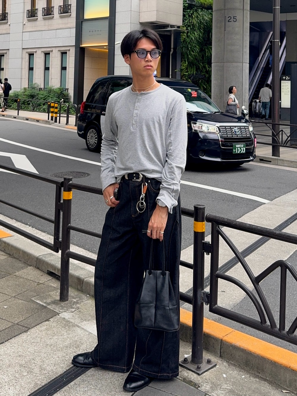 グレー系のTシャツ/カットソー、ブラック系のデニムパンツ、ブラック系のバッグを着用したメンズの夏コーディネートの1枚目の写真