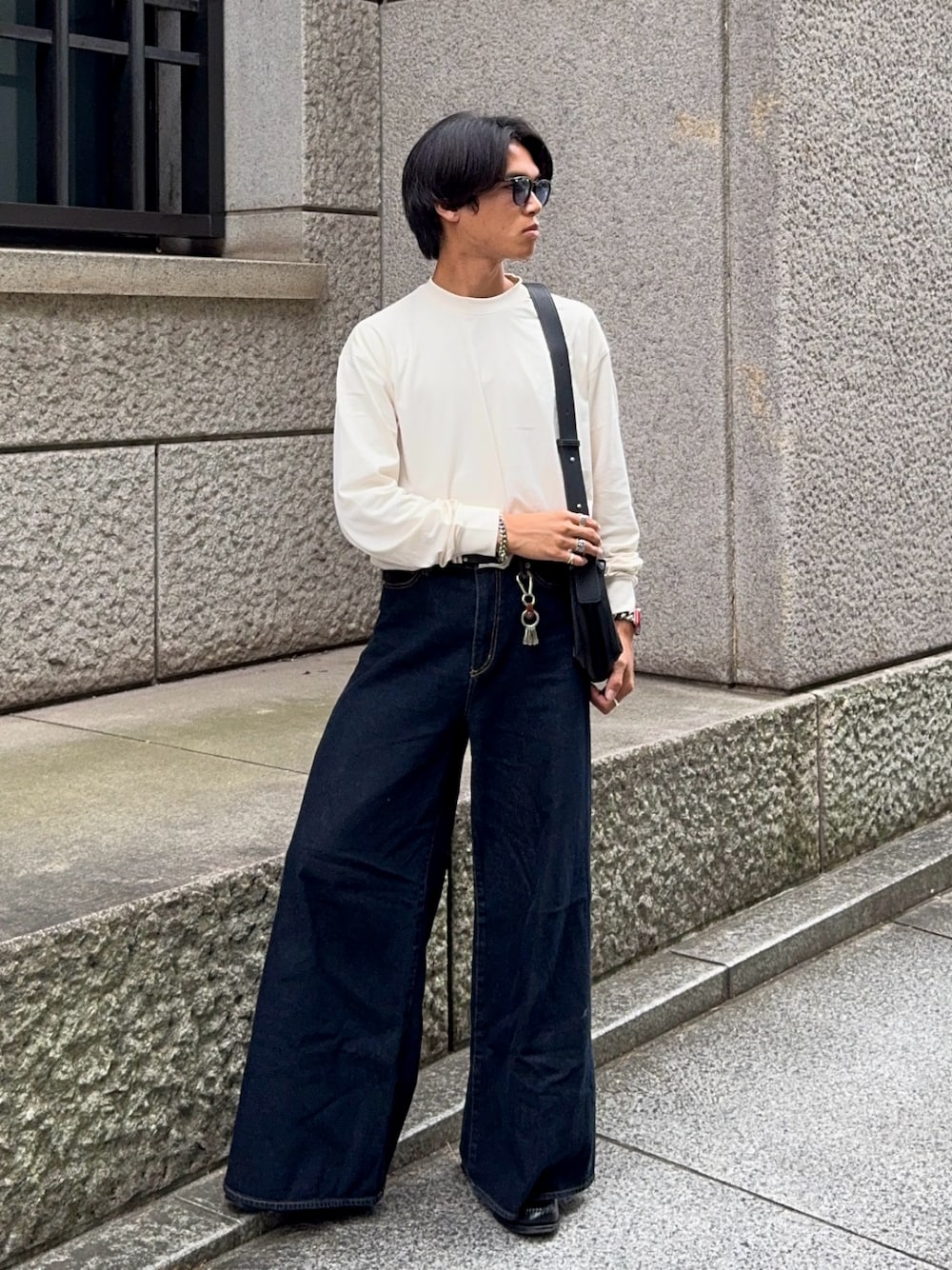 ベージュ系のTシャツ/カットソー、ブラック系のローファー、ブルー系のデニムパンツを着用したメンズの秋コーディネートの1枚目の写真