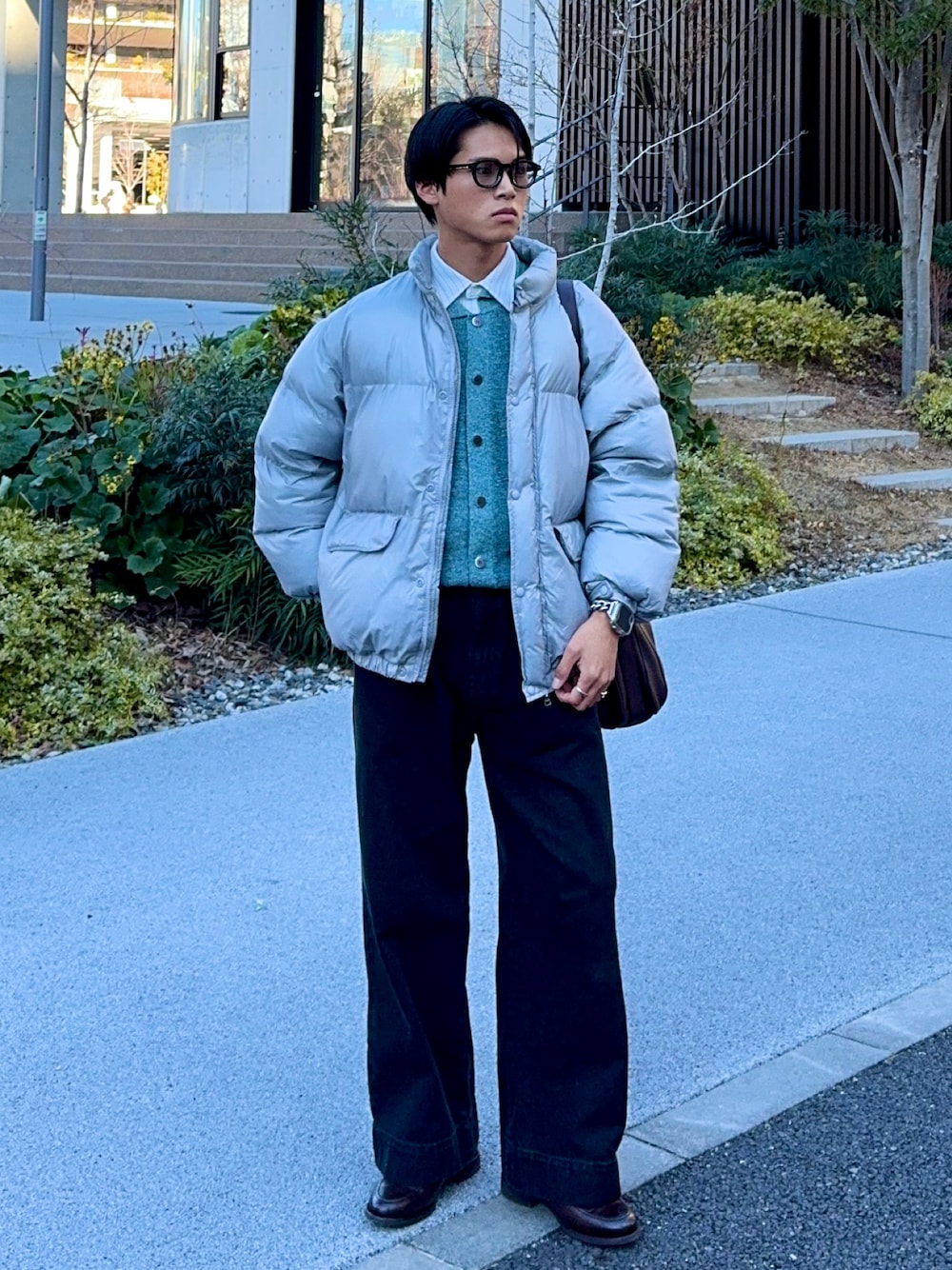 ブラック系のデニムパンツ、ブラウン系のローファー、グレー系のダウンジャケット/コートを着用したメンズの冬コーディネートの1枚目の写真