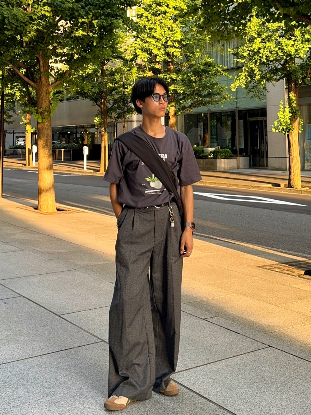 ベージュ系のスニーカー、グレー系のスラックス、グレー系のTシャツ/カットソーを着用したメンズの夏コーディネートの1枚目の写真
