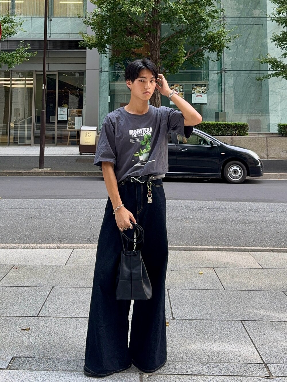 ブラック系のバッグ、ブルー系のデニムパンツ、グレー系のTシャツ/カットソーを着用したメンズの夏コーディネートの1枚目の写真