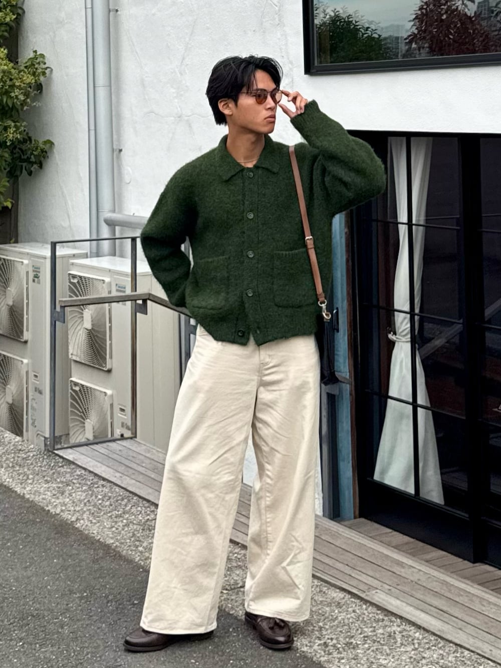 グリーン系のカーディガン/ボレロ、ホワイト系のデニムパンツ、ブラウン系のローファーを着用したメンズの秋コーディネートの1枚目の写真
