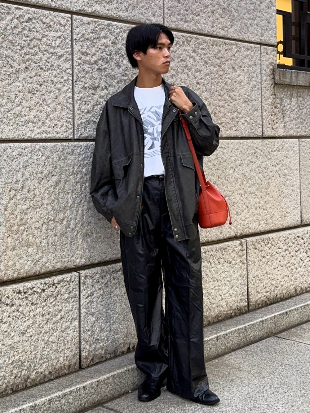 ブラック系のブルゾン、その他のTシャツ/カットソー、オレンジ系のバッグを着用したメンズの秋コーディネートの1枚目の写真
