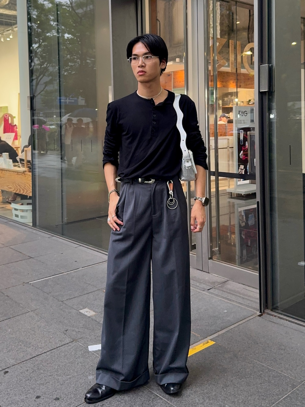 ブラック系のTシャツ/カットソー、グレー系のスラックス、シルバー系のショルダーバッグを着用したメンズの夏コーディネートの1枚目の写真
