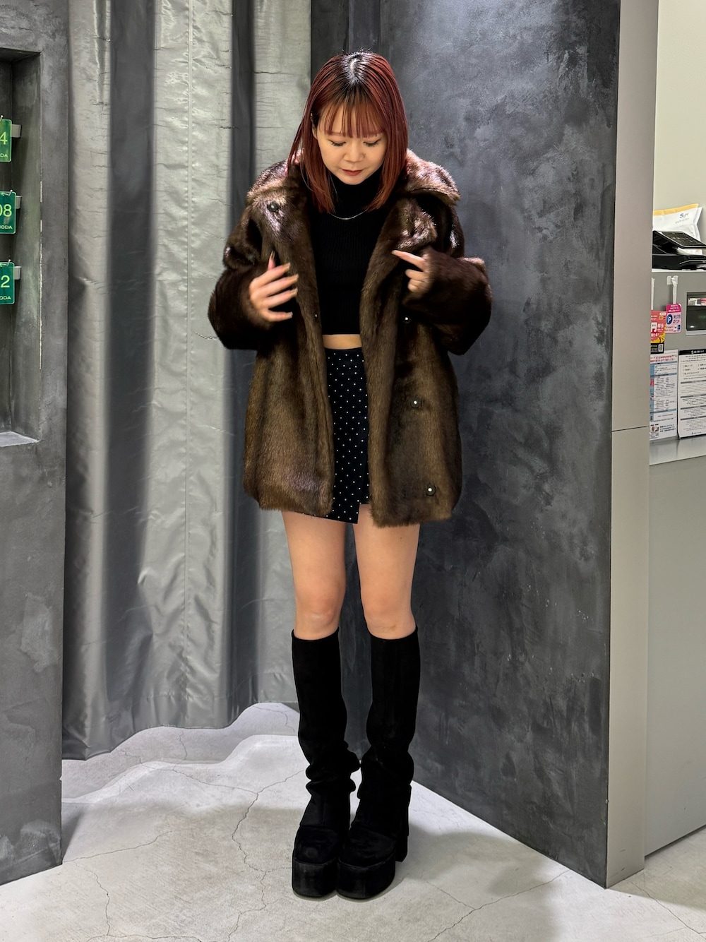 ブラウン系のその他アウター、ブルー系のスカート、ブラック系のブーツを着用したレディースの秋コーディネートの1枚目の写真