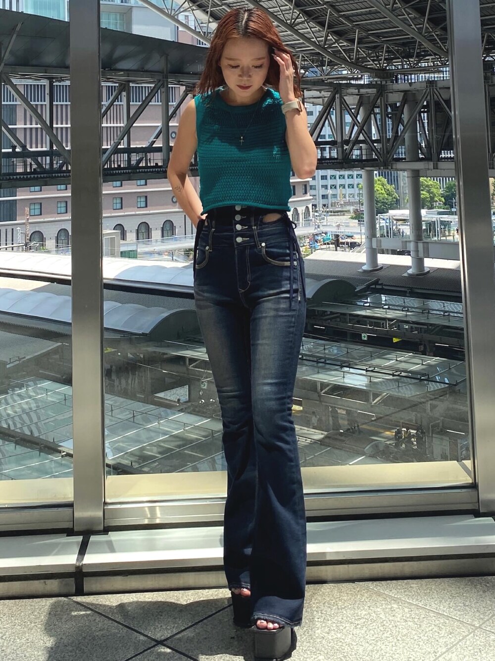 グリーン系のタンクトップ、ホワイト系のキャミソール、ブルー系のデニムパンツを着用したレディースの夏コーディネートの1枚目の写真