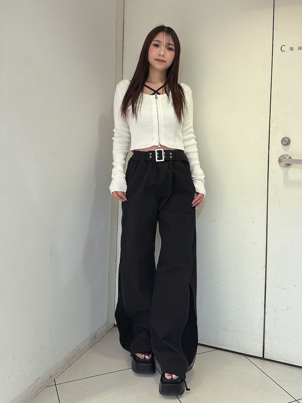 ブラック系のその他パンツ、ブラック系のサンダル、ホワイト系のニット/セーターを着用したレディースの春コーディネートの1枚目の写真