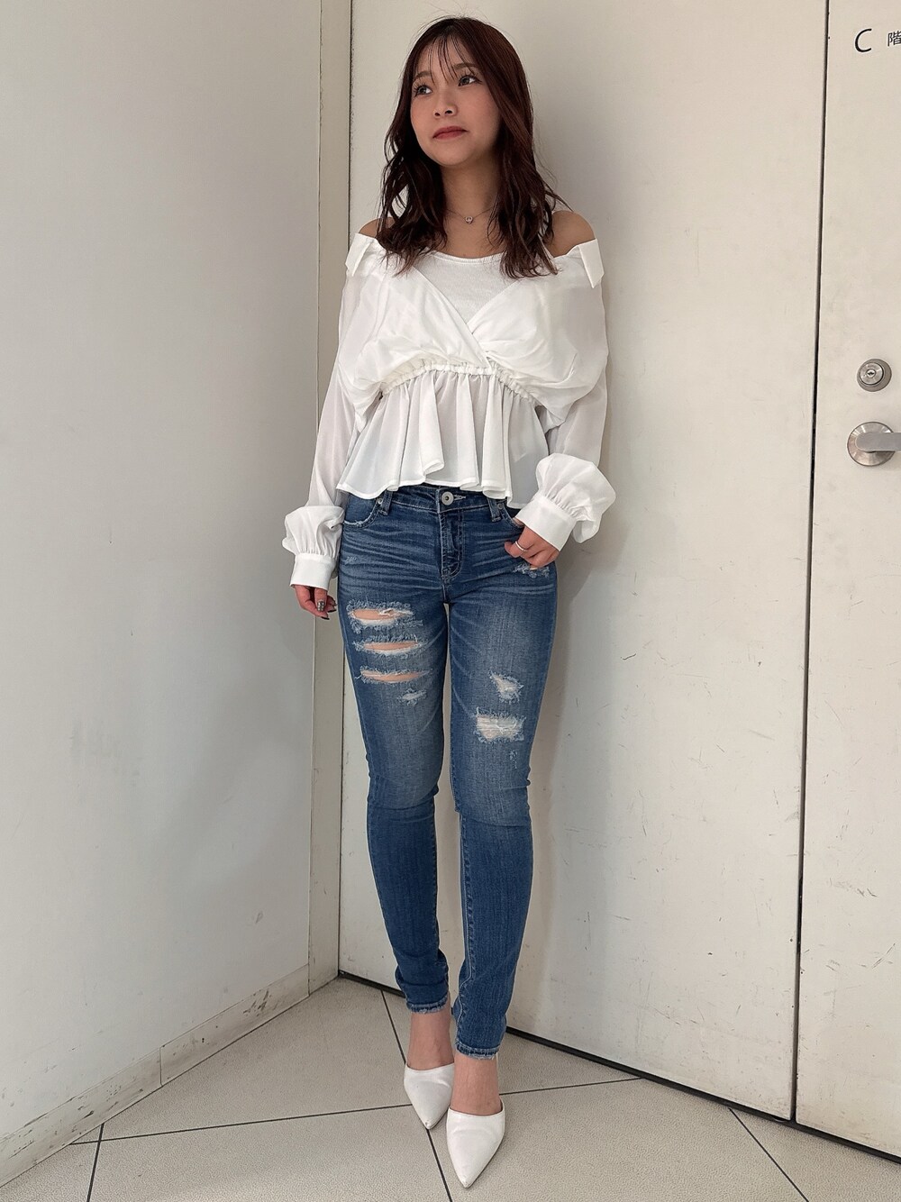 ブルー系のデニムパンツ、ホワイト系のパンプス、ホワイト系のシャツ/ブラウスを着用したレディースの冬コーディネートの1枚目の写真