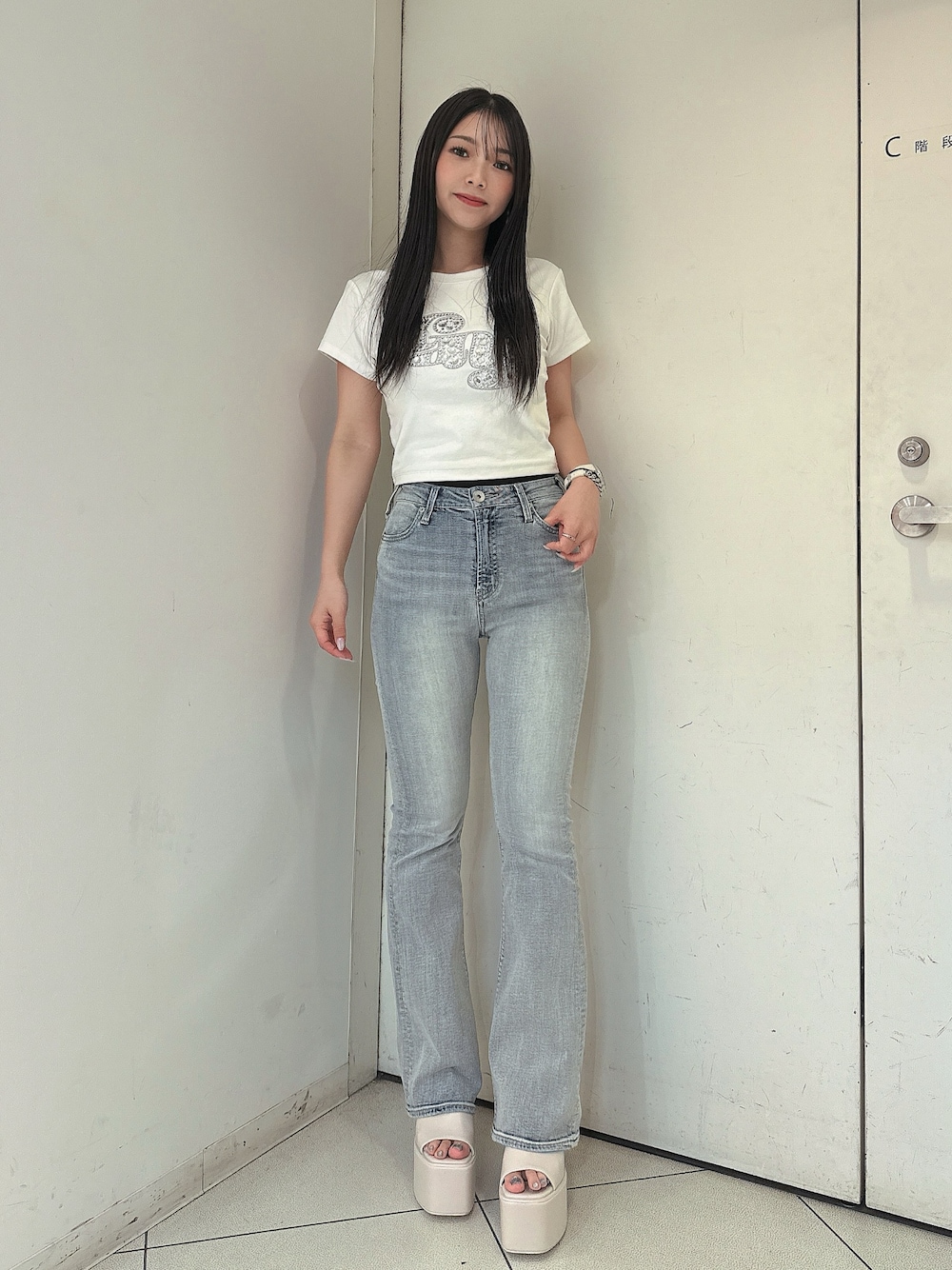 ブルー系のデニムパンツ、ホワイト系のTシャツ/カットソー、ホワイト系のサンダルを着用したレディースの春コーディネートの1枚目の写真