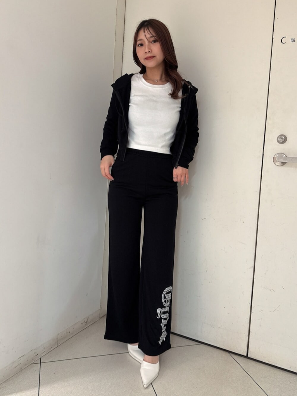 ホワイト系のパンプス、ブラック系のパーカー、ホワイト系のTシャツ/カットソーを着用したレディースの春コーディネートの1枚目の写真