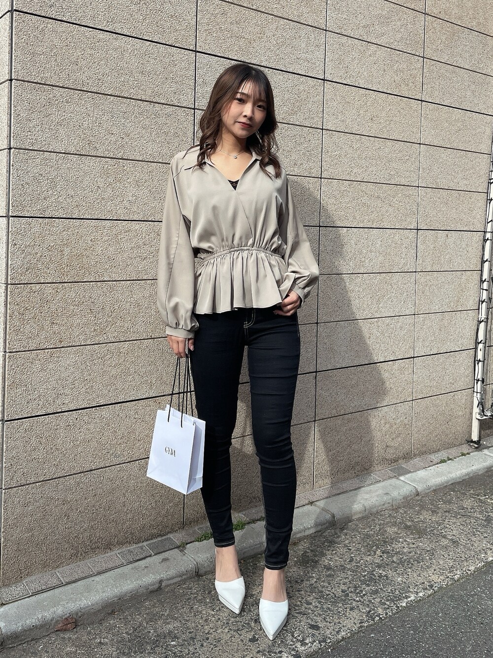 ベージュ系のシャツ/ブラウス、ブラック系のキャミソール、ブラック系のデニムパンツを着用したレディースの冬コーディネートの1枚目の写真