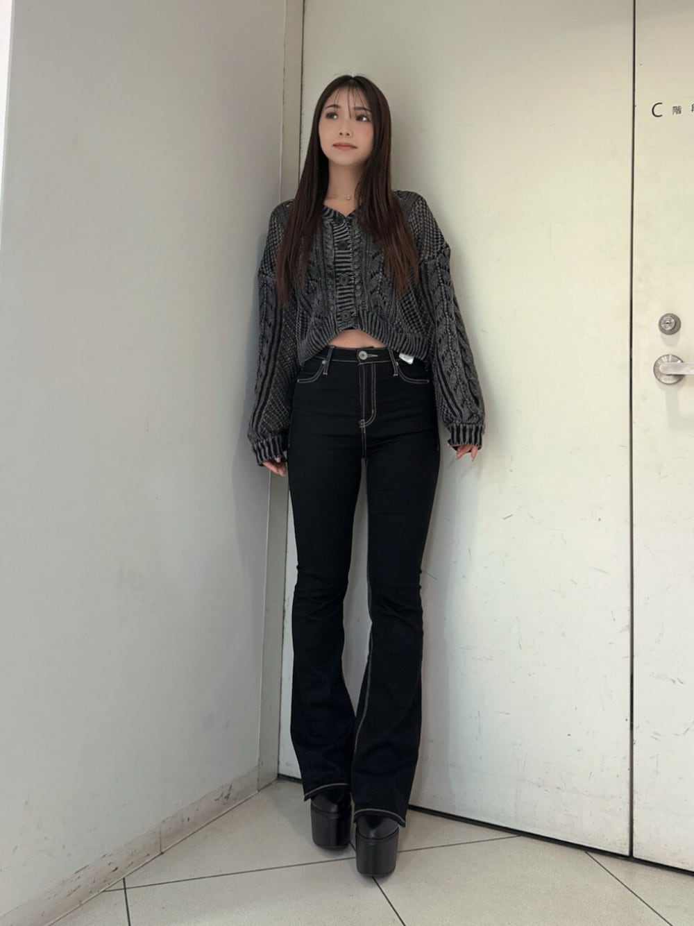 ブラック系のデニムパンツ、ブラック系のブーツ、ブラック系のニット/セーターを着用したレディースの夏コーディネートの1枚目の写真