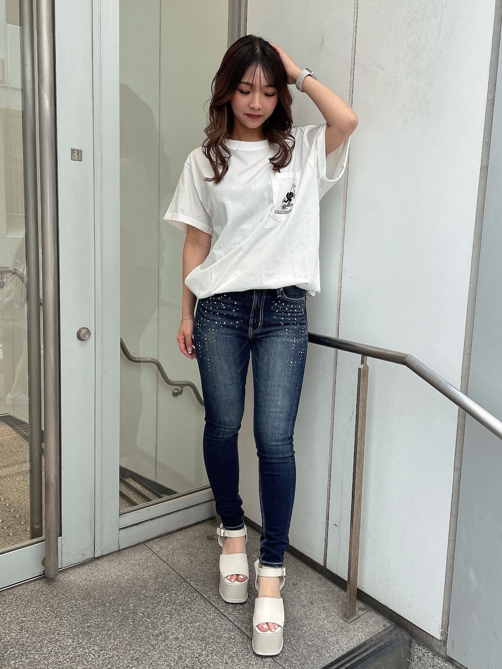 ホワイト系のTシャツ/カットソー、ブルー系のデニムパンツ、ホワイト系のサンダルを着用したレディースの夏コーディネートの1枚目の写真