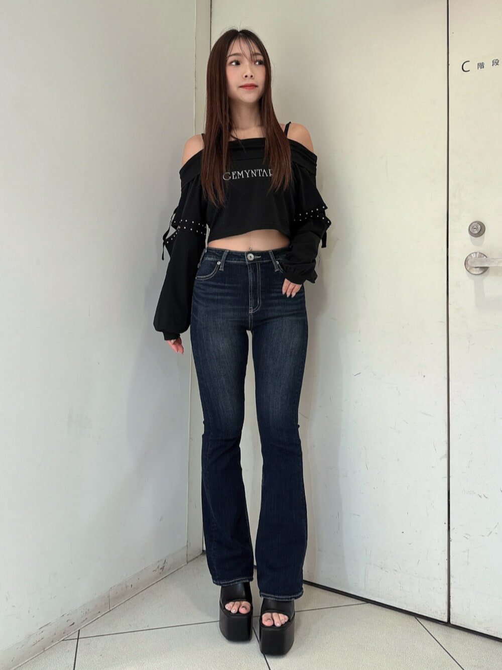 ブルー系のデニムパンツ、ブラック系のサンダル、ブラック系のTシャツ/カットソーを着用したレディースの春コーディネートの1枚目の写真