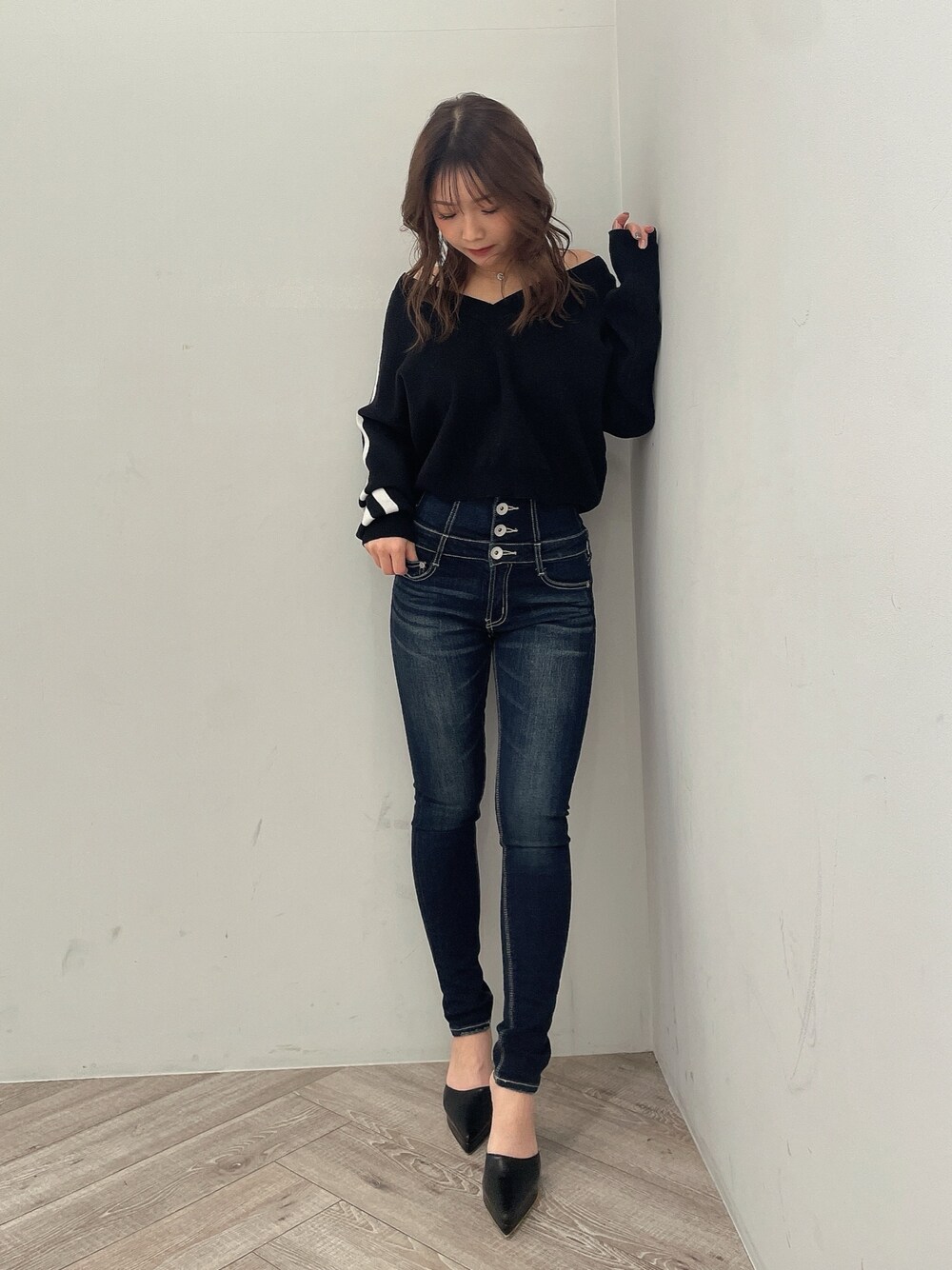 ブラック系のニット/セーター、ブルー系のデニムパンツ、ブラック系のパンプスを着用したレディースの冬コーディネートの1枚目の写真