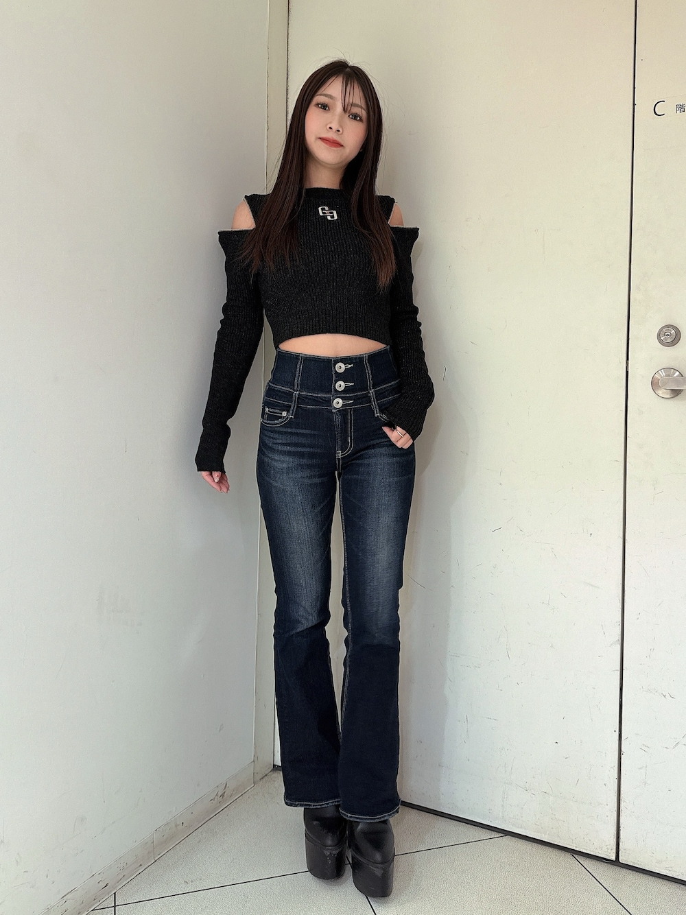 ブルー系のデニムパンツ、ブラック系のブーツ、ブラック系のニット/セーターを着用したレディースの冬コーディネートの1枚目の写真