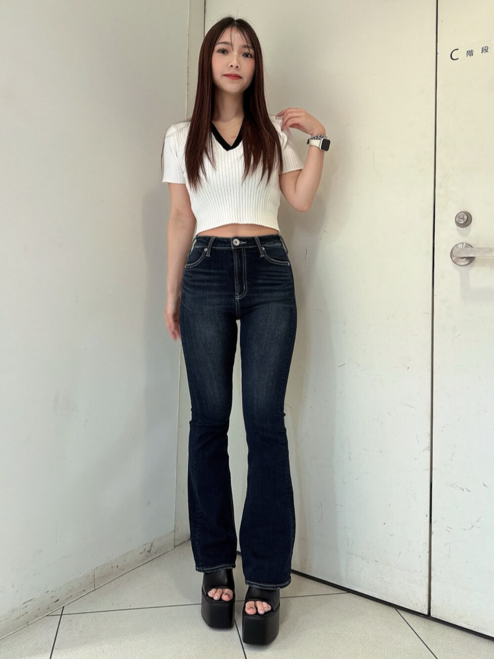 ブルー系のデニムパンツ、ブラック系のサンダル、ホワイト系のニット/セーターを着用したレディースの春コーディネートの1枚目の写真