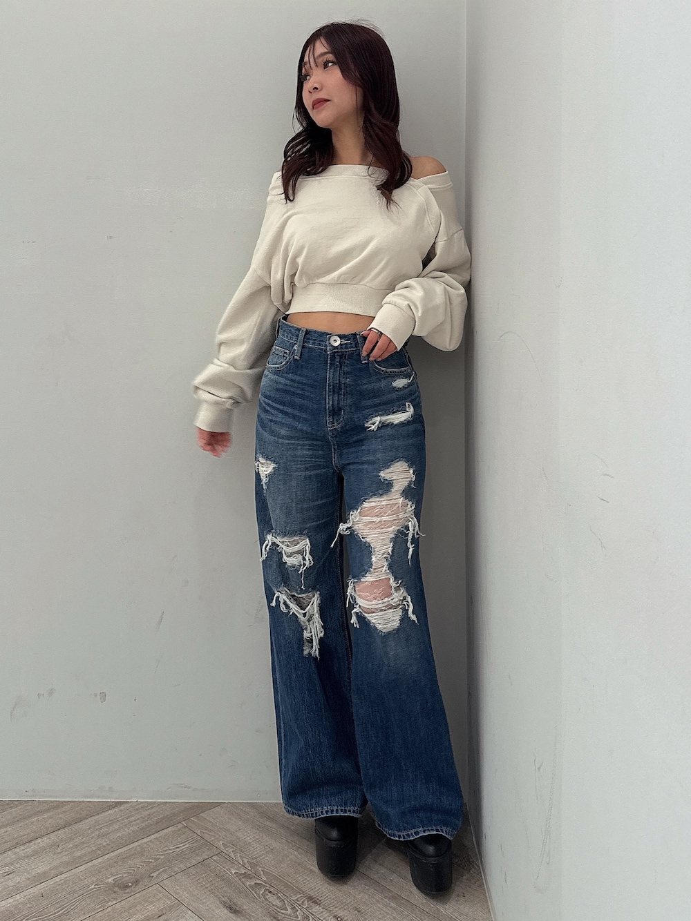 ホワイト系のスウェット、ブルー系のデニムパンツ、ブラック系のブーツを着用したレディースの秋コーディネートの1枚目の写真