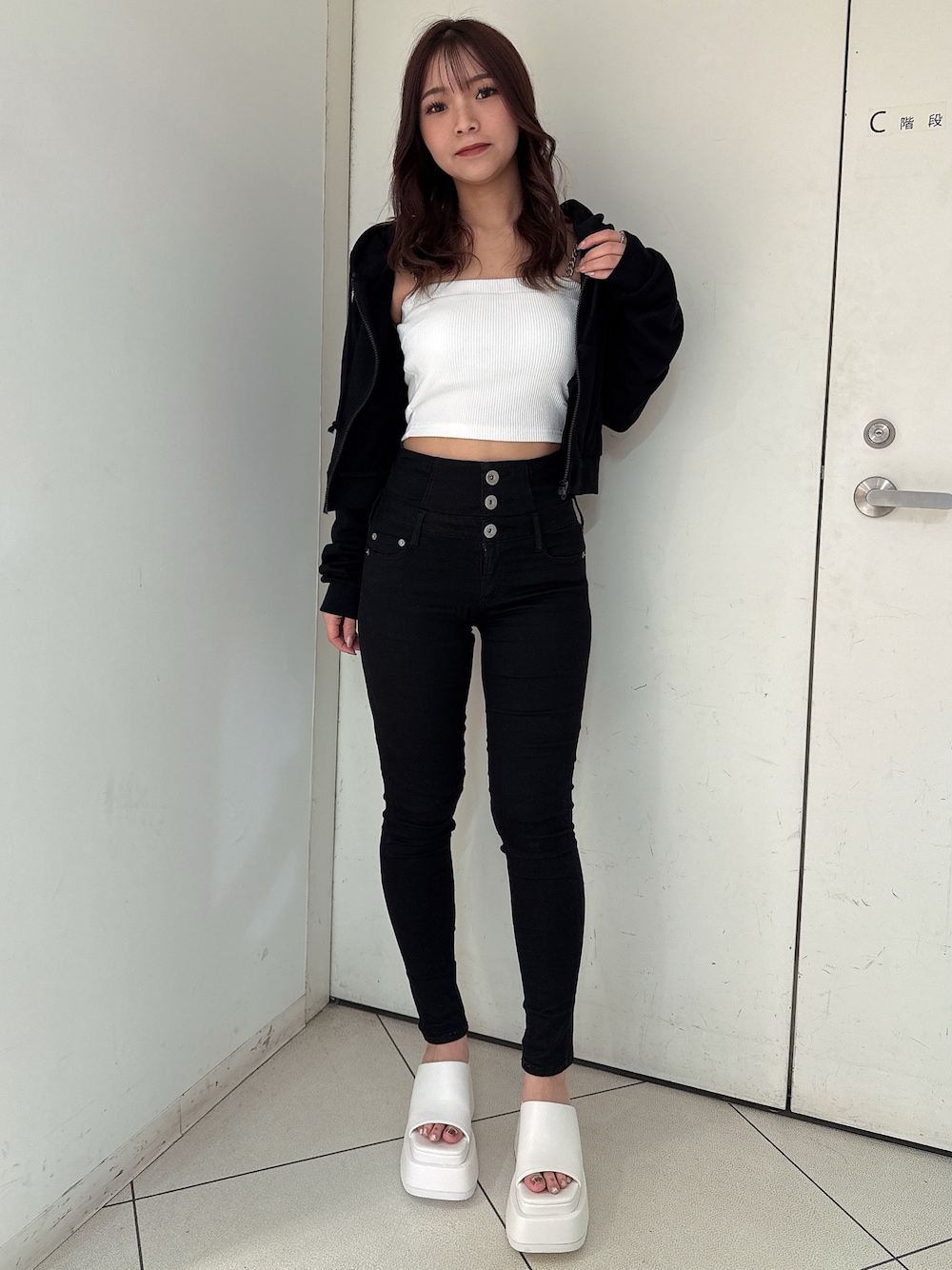 ブラック系のデニムパンツ、ホワイト系のサンダル、ホワイト系のキャミソールを着用したレディースの春コーディネートの1枚目の写真