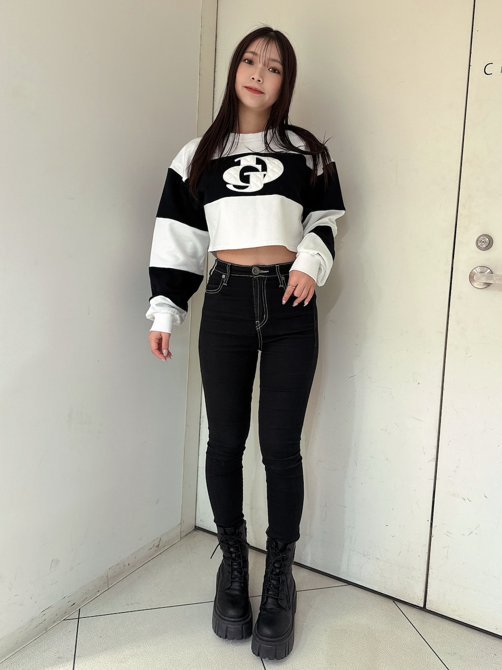 ブラック系のデニムパンツ、ブラック系のブーツ、ホワイト系のTシャツ/カットソーを着用したレディースの冬コーディネートの1枚目の写真