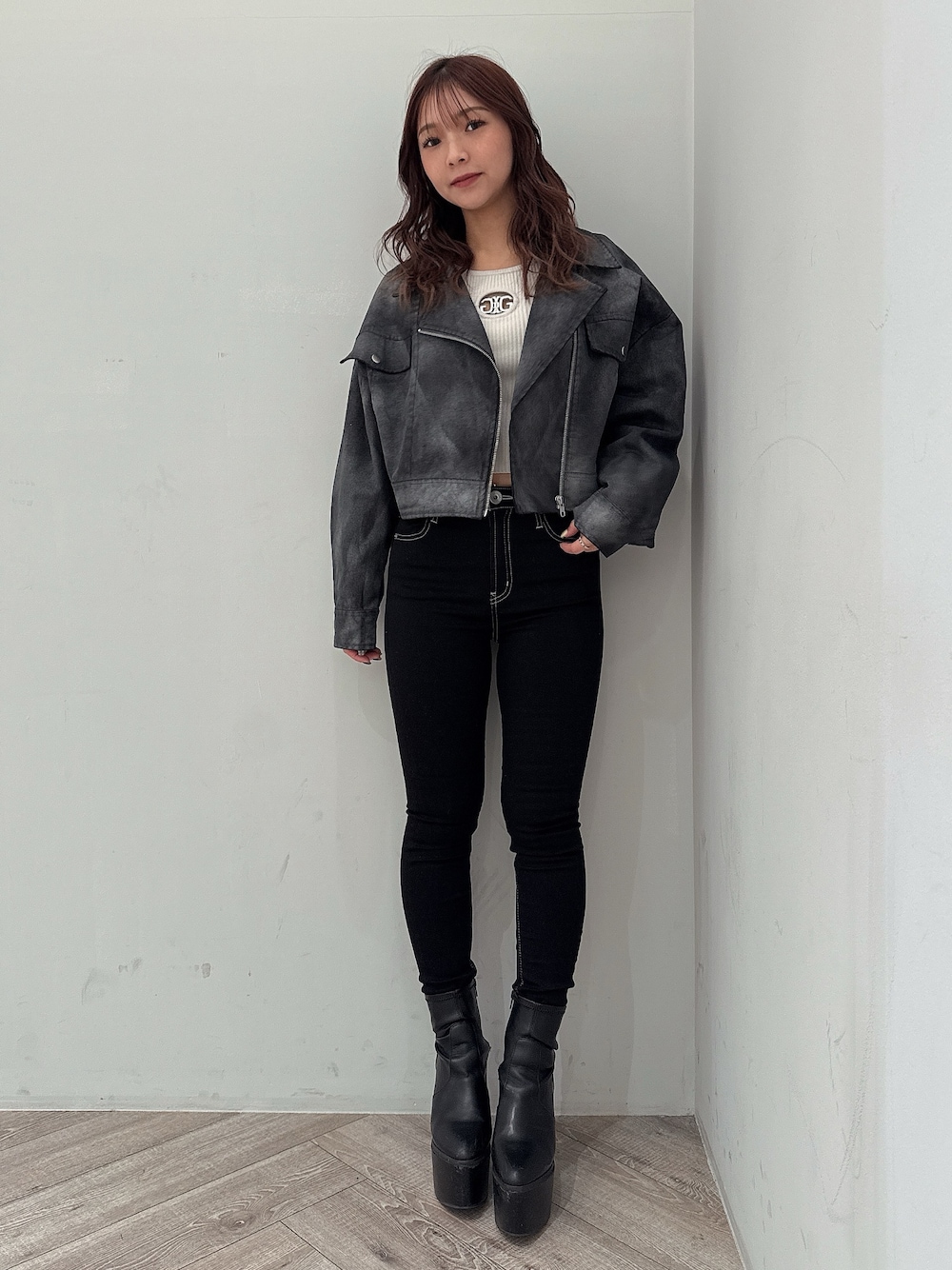 ブラック系のテーラードジャケット、グレー系のニット/セーター、ブラック系のデニムパンツを着用したレディースの冬コーディネートの1枚目の写真