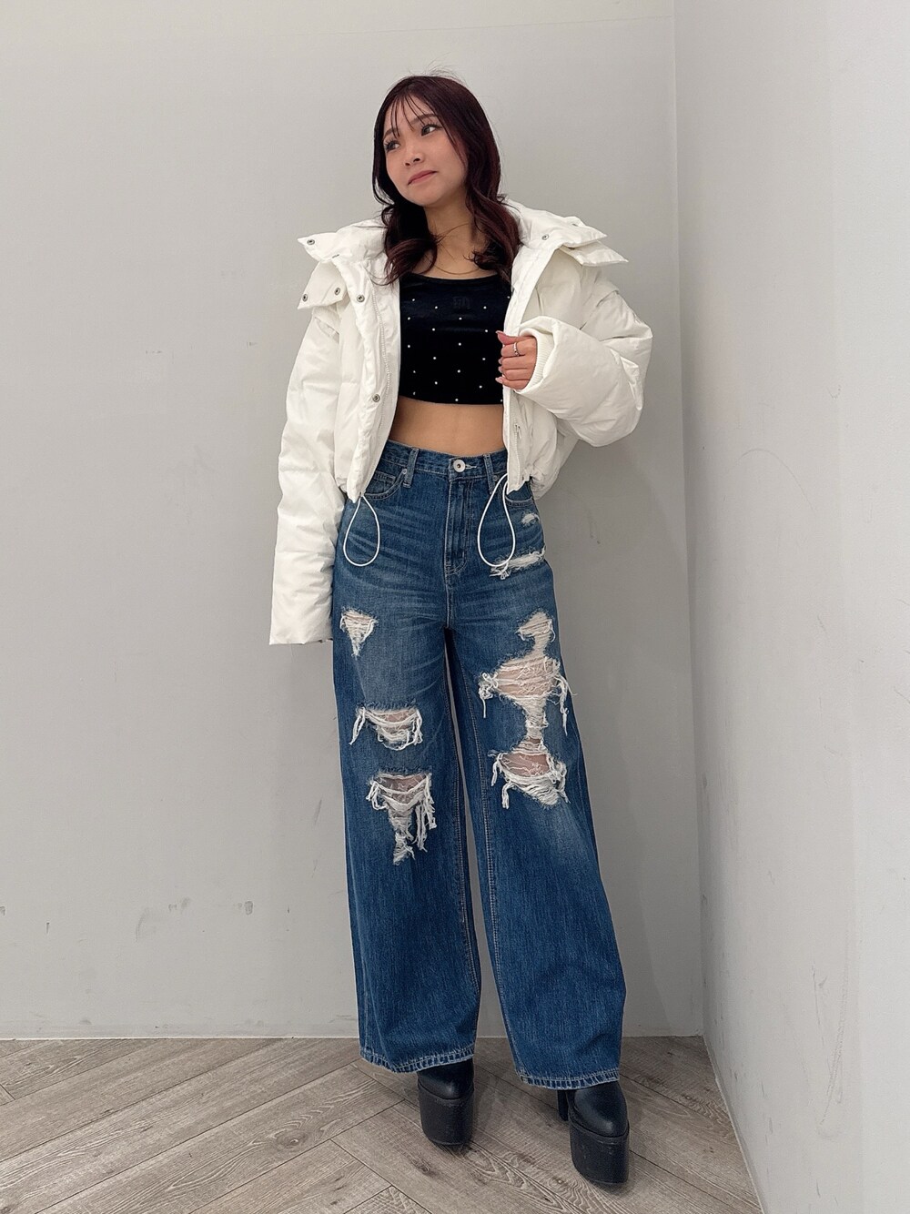 ホワイト系のダウンジャケット/コート、ブルー系のデニムパンツ、ブラック系のブーツを着用したレディースの秋コーディネートの1枚目の写真