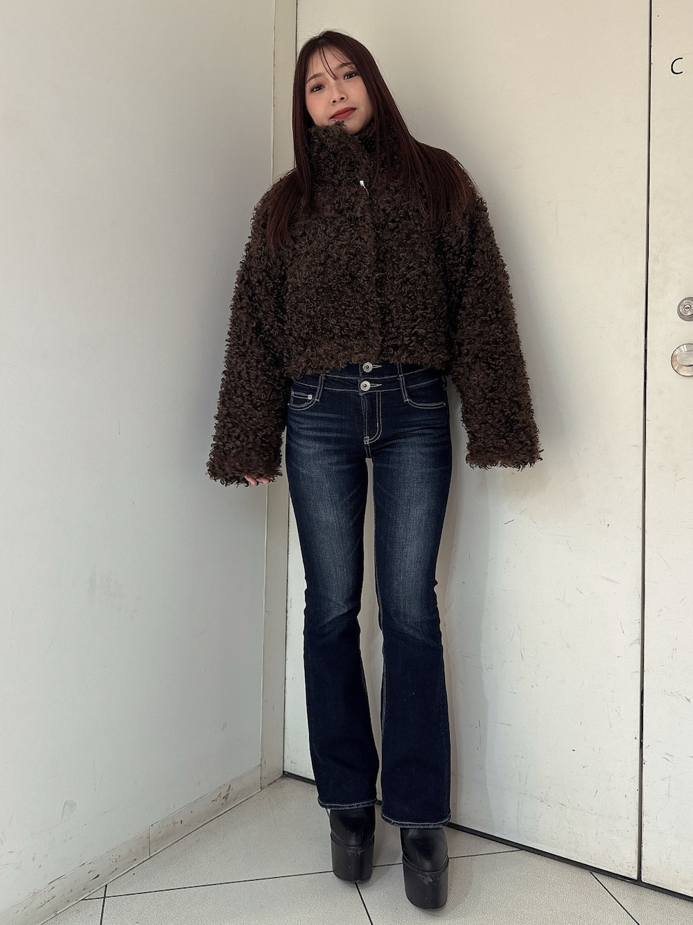 ブルー系のデニムパンツ、ブラック系のブーツ、ブラウン系のブルゾンを着用したレディースの秋コーディネートの1枚目の写真