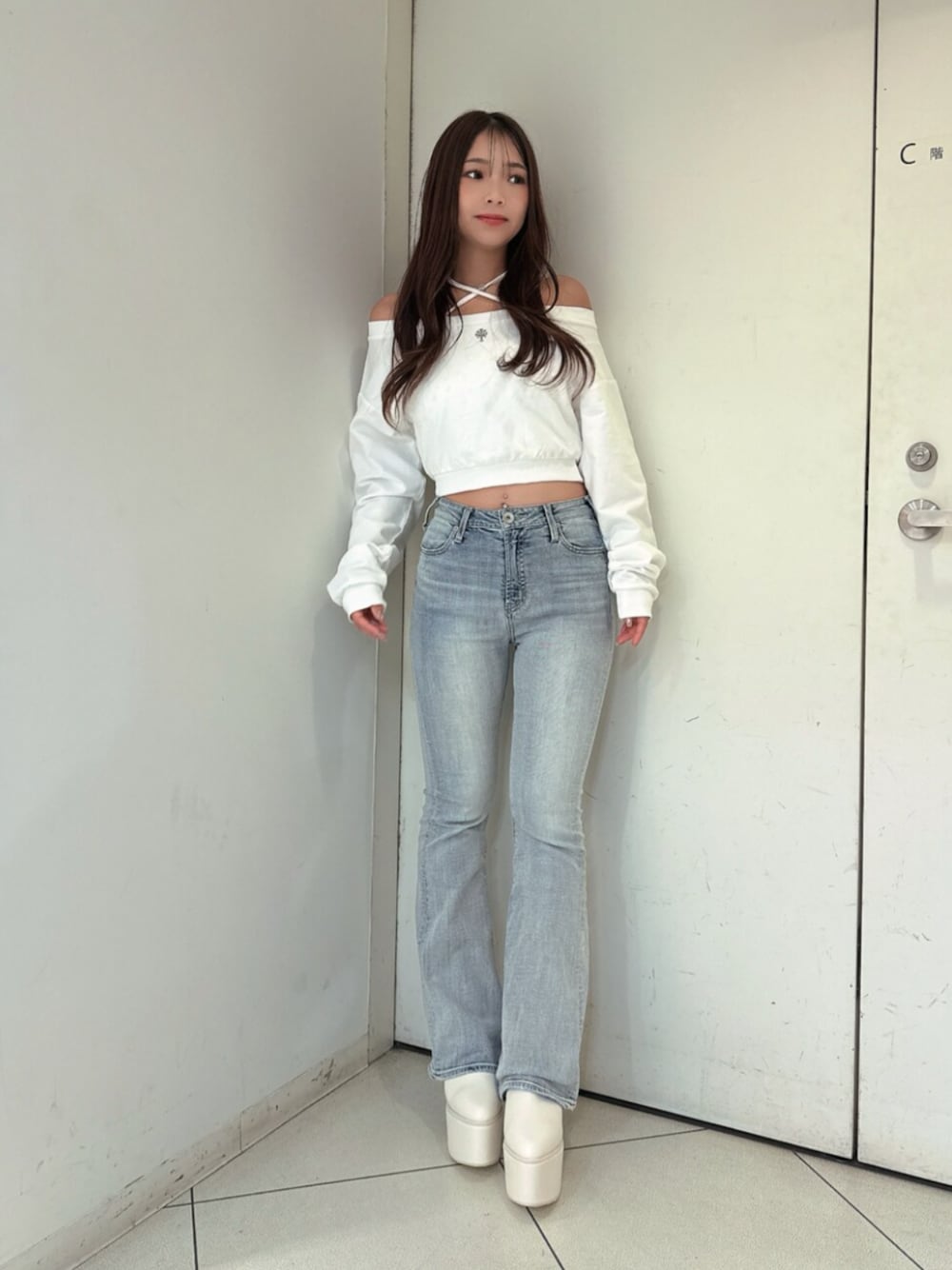 ブルー系のデニムパンツ、ホワイト系のスウェット、ホワイト系のブーツを着用したレディースの夏コーディネートの1枚目の写真