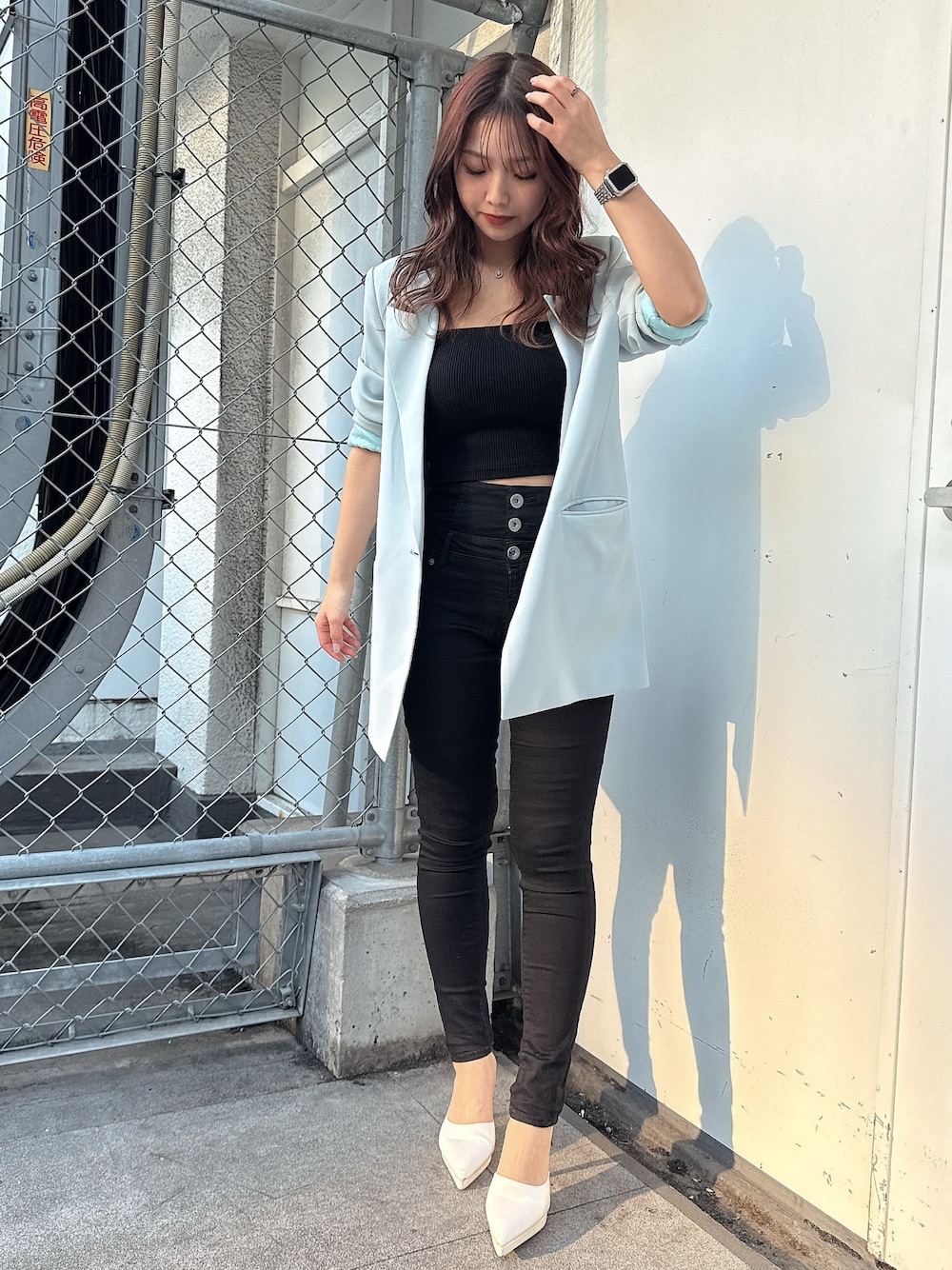 ブラック系のキャミソール、ブラック系のデニムパンツ、ホワイト系のパンプスを着用したレディースの春コーディネートの1枚目の写真