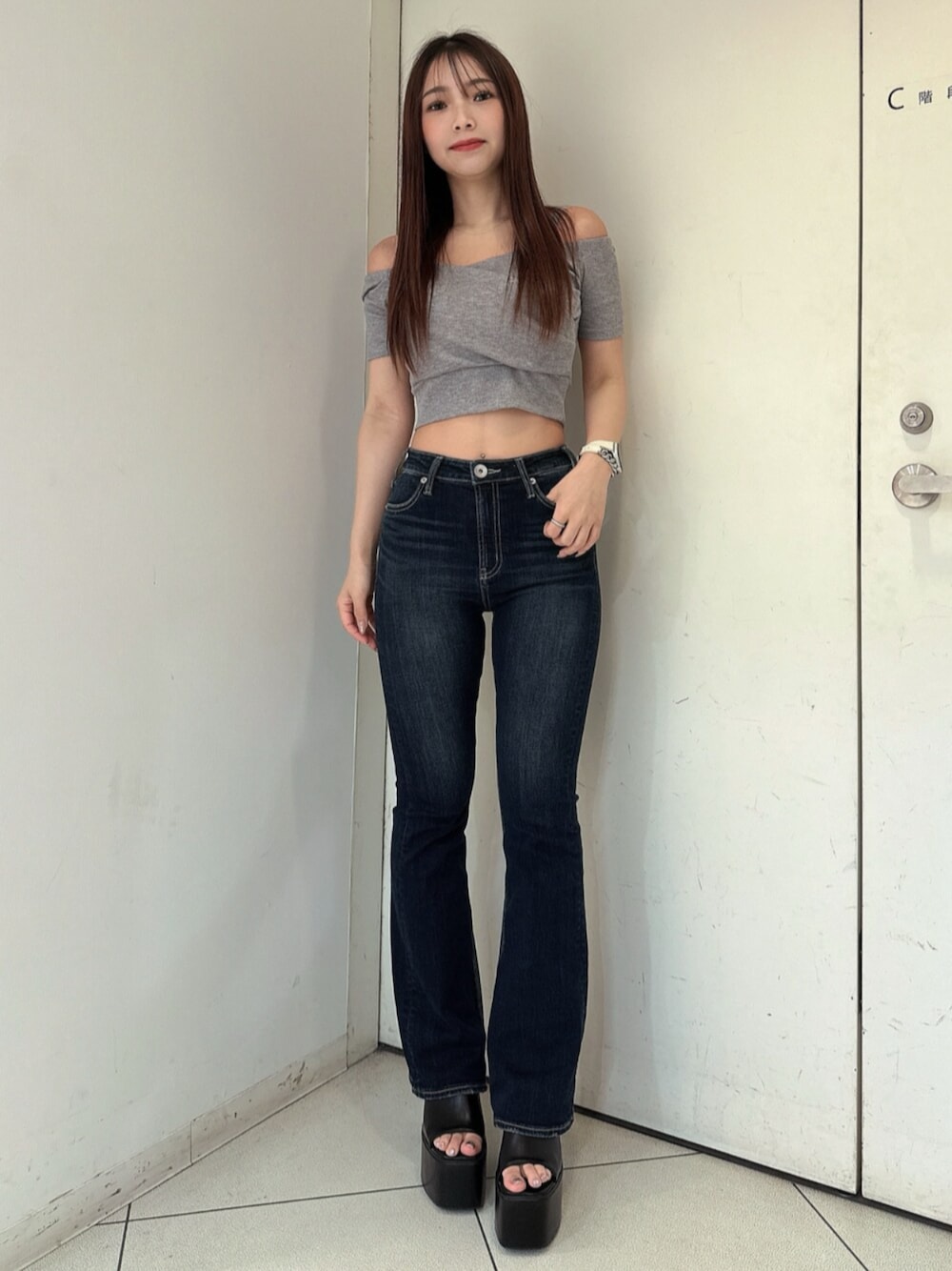 ブルー系のデニムパンツ、ブラック系のサンダル、グレー系のTシャツ/カットソーを着用したレディースの春コーディネートの1枚目の写真