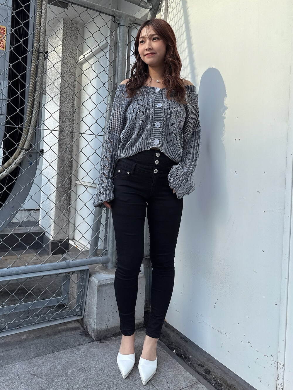 ブルー系のニット/セーター、ブラック系のデニムパンツ、ホワイト系のパンプスを着用したレディースの春コーディネートの1枚目の写真