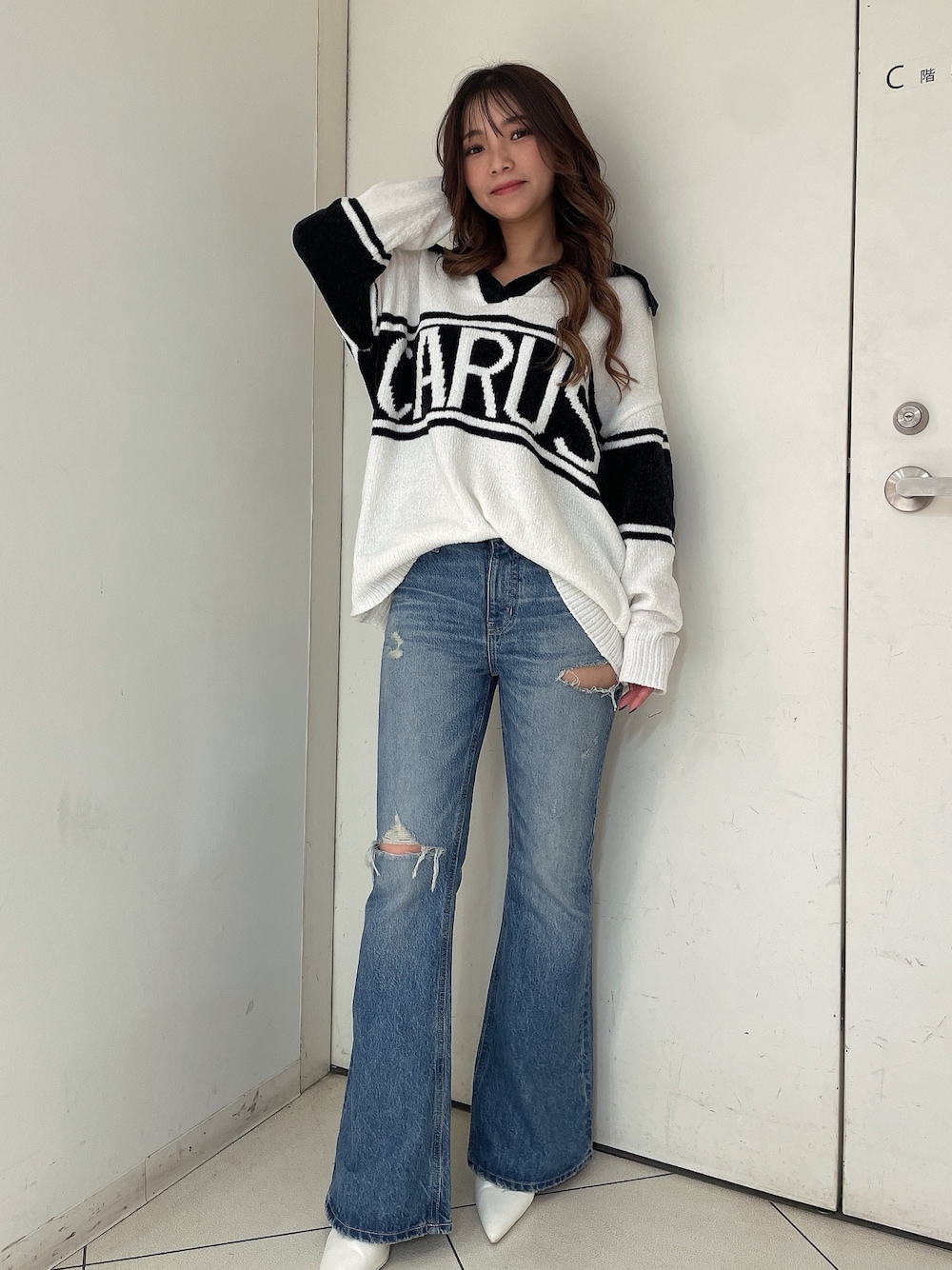 ホワイト系のニット/セーター、ブルー系のデニムパンツ、ホワイト系のパンプスを着用したレディースの秋コーディネートの1枚目の写真