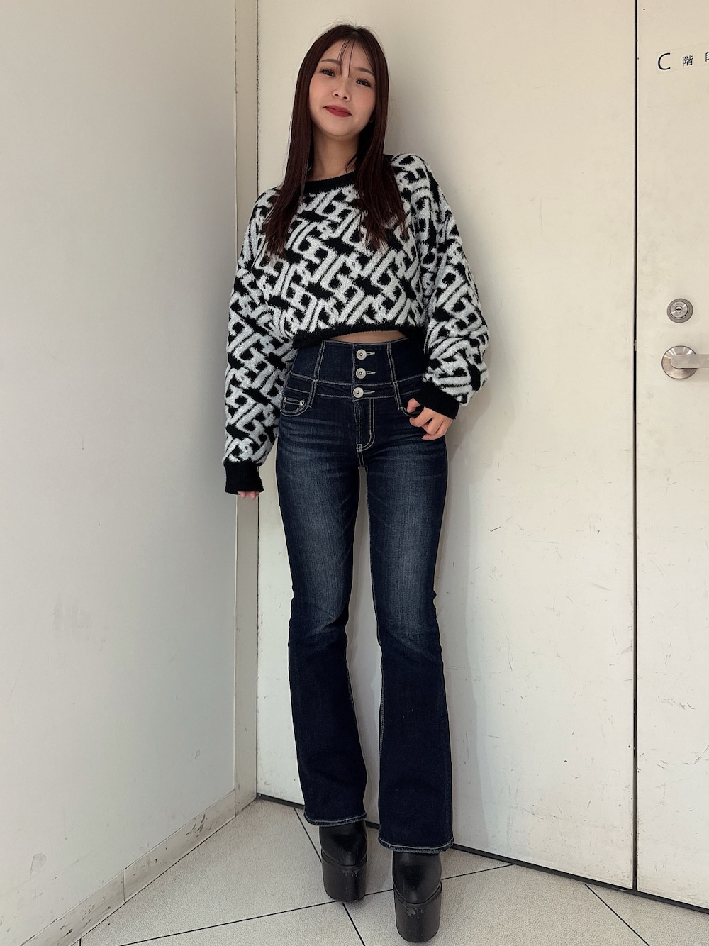 ブルー系のデニムパンツ、ブラック系のブーツ、ブラック系のニット/セーターを着用したレディースの秋コーディネートの1枚目の写真