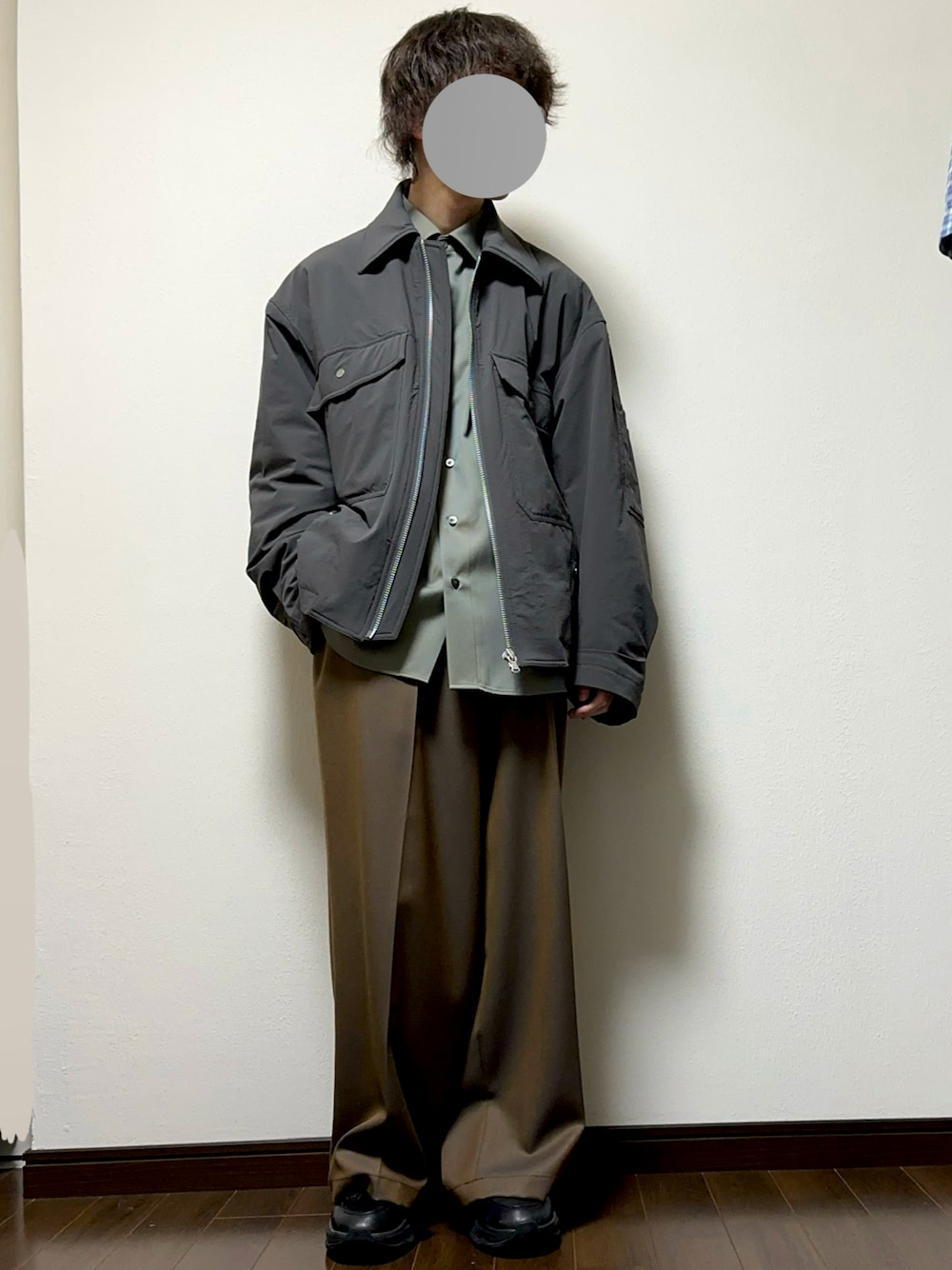 グリーン系のシャツ/ブラウス、グレー系のダウンジャケット/コート、ブラウン系のスラックスを着用したメンズの秋コーディネートの1枚目の写真