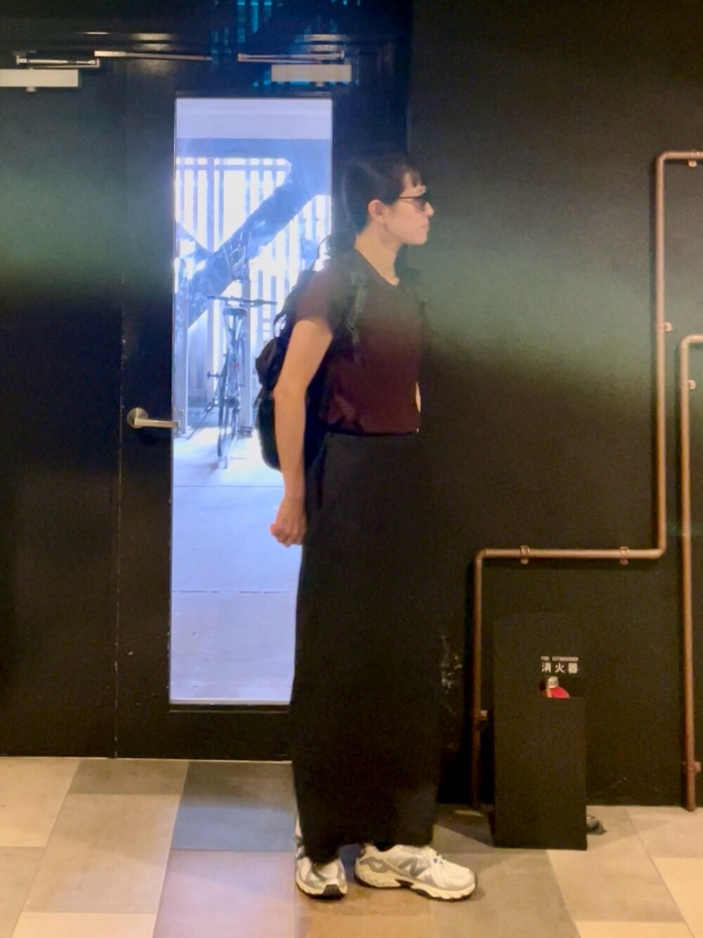 ブラック系のスカート、シルバー系のスニーカー、ブラウン系のTシャツ/カットソーを着用したレディースの秋コーディネートの1枚目の写真