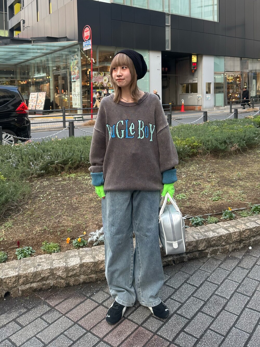 ブラック系のニット/セーター、ブルー系のデニムパンツ、シルバー系のボストンバッグを着用したレディースの冬コーディネートの1枚目の写真