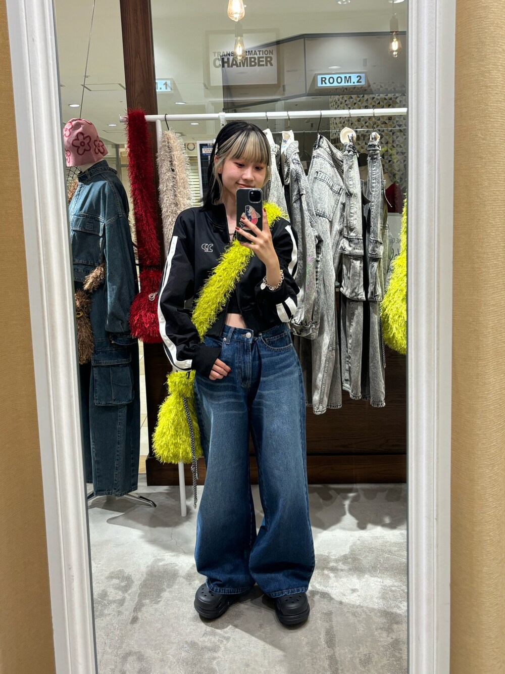 ブルー系のデニムパンツ、イエロー系のショルダーバッグ、ブラック系のジャージを着用したレディースの秋コーディネートの1枚目の写真