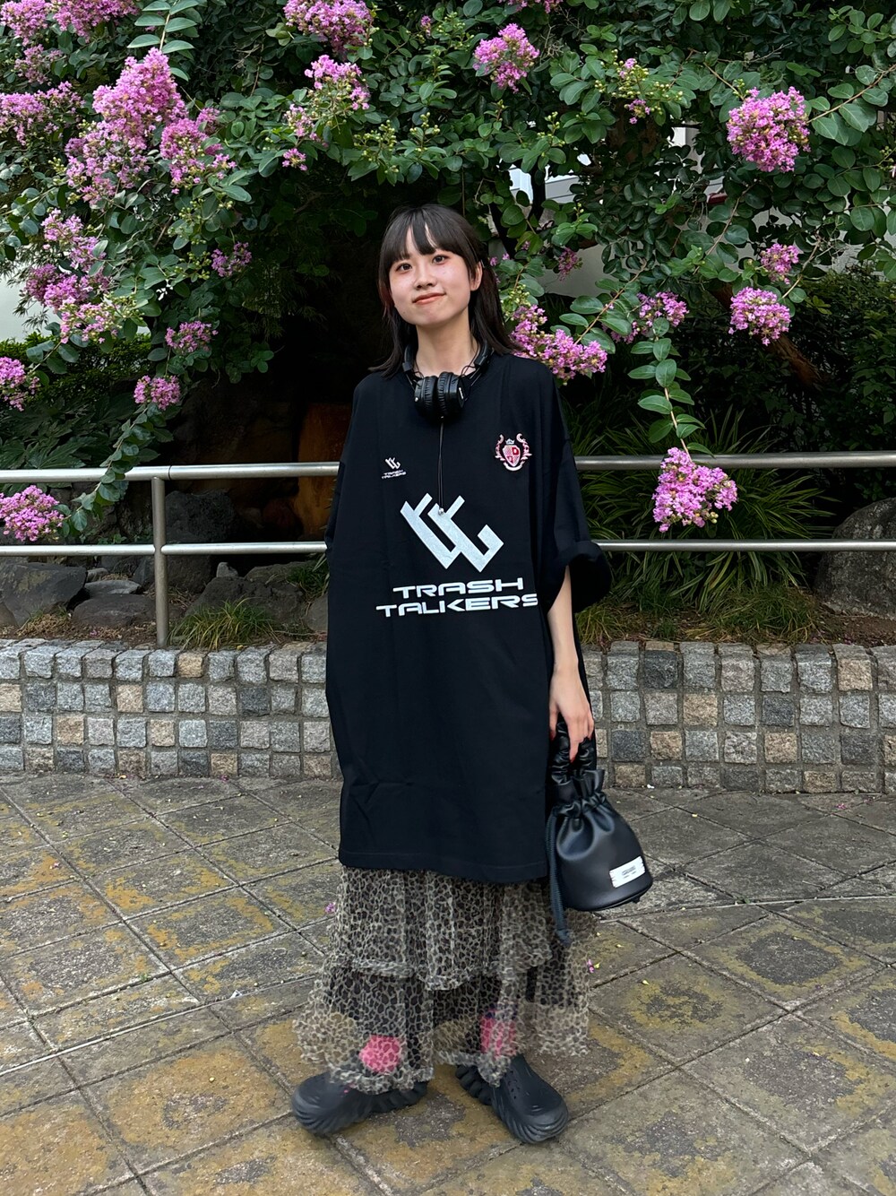 ブラック系のTシャツ/カットソー、ベージュ系のスカート、ブラック系のハンドバッグを着用したレディースの夏コーディネートの1枚目の写真