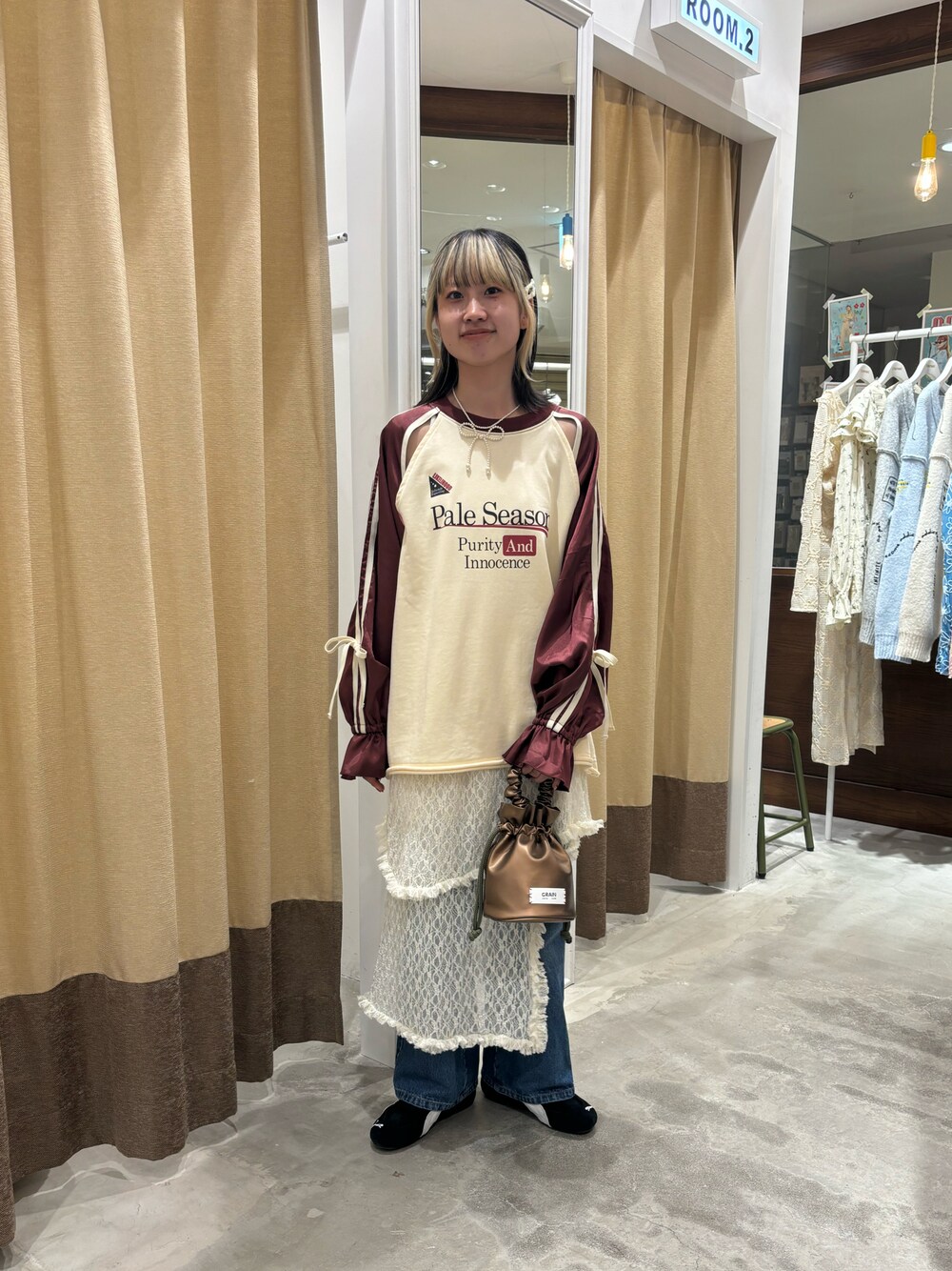 レッド系のTシャツ/カットソー、ゴールド系のハンドバッグ、ホワイト系のスカートを着用したレディースの秋コーディネートの1枚目の写真