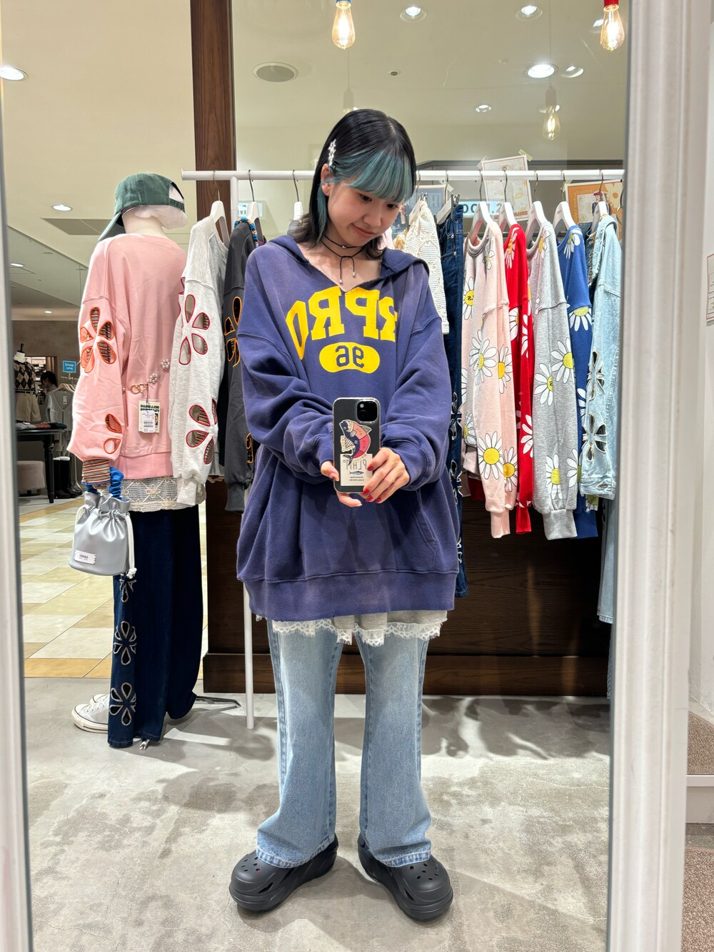 ブラック系のパーカー、グレー系のスカート、ブルー系のデニムパンツを着用したレディースの秋コーディネートの1枚目の写真