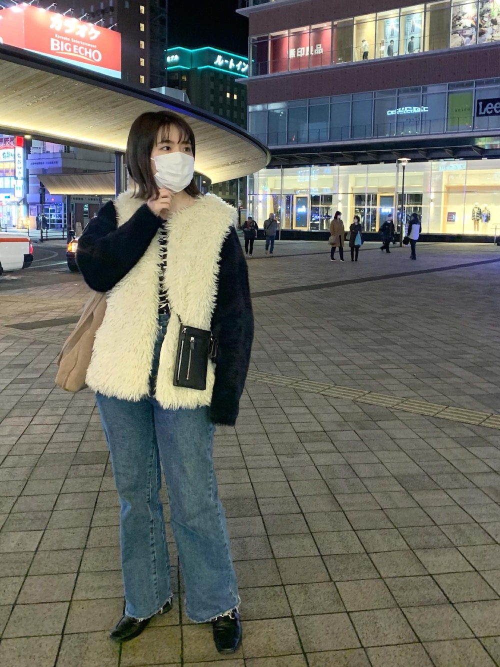 ブルー系のデニムパンツ、ホワイト系のベスト、ブラック系のローファーを着用したレディースの冬コーディネートの1枚目の写真