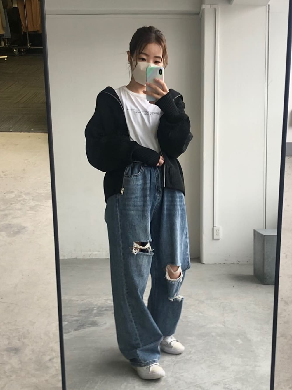 ブラック系のカーディガン/ボレロ、ブルー系のデニムパンツを着用したレディースの秋コーディネートの1枚目の写真