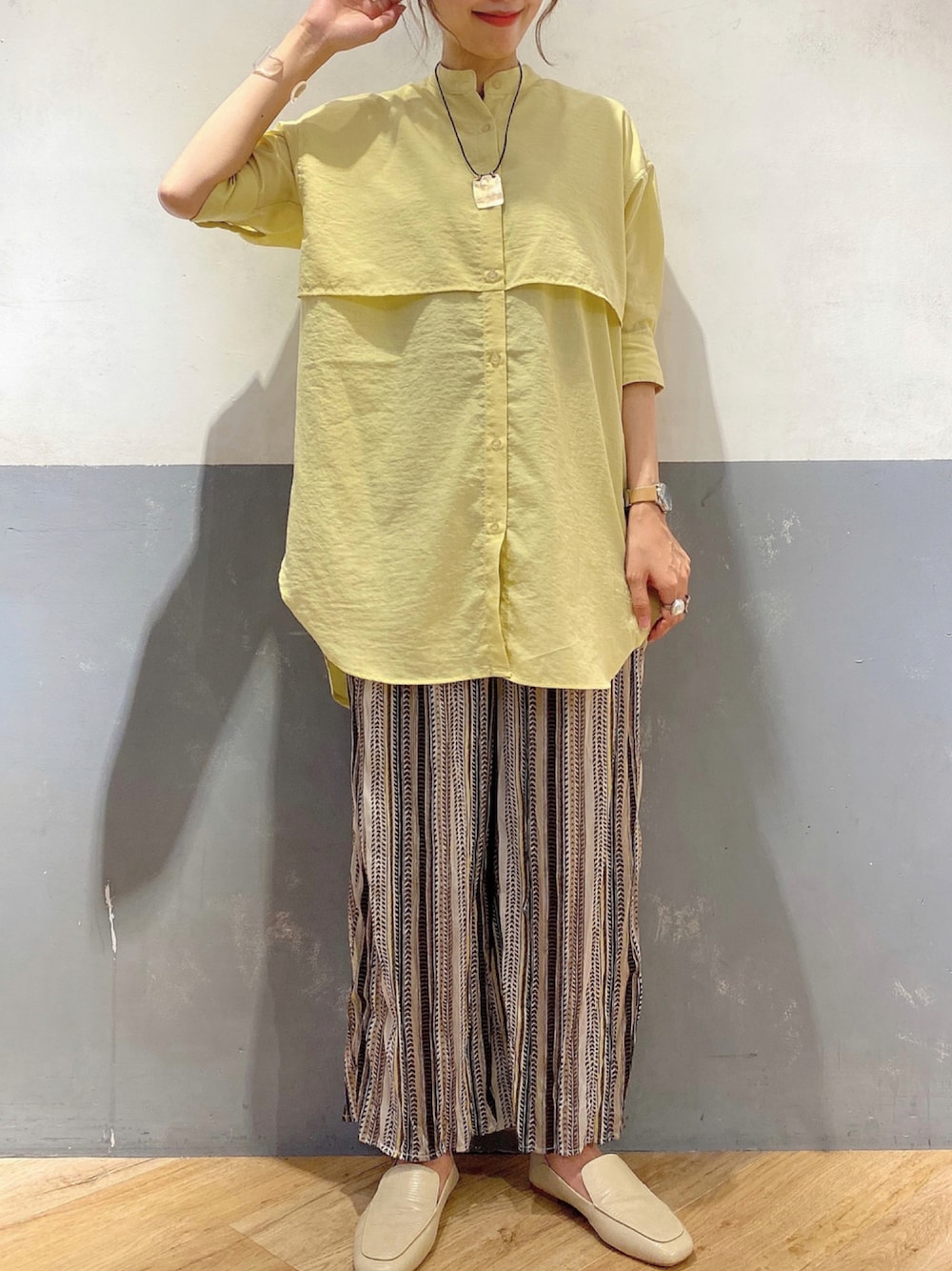 イエロー系のシャツ/ブラウス、ブラック系のその他パンツ、ベージュ系のパンプスを着用したレディースの夏コーディネートの1枚目の写真